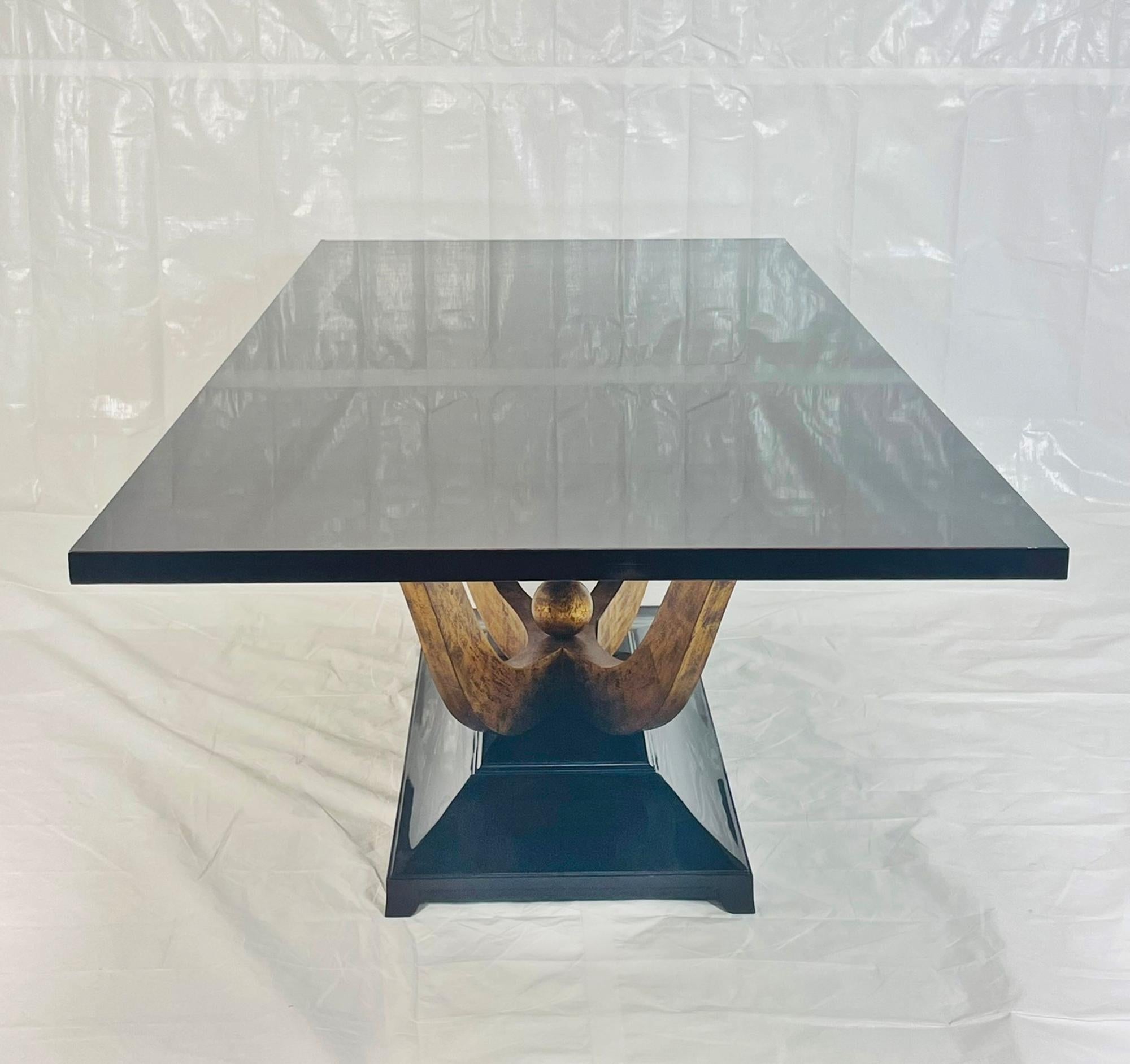 Elegante y escultural mesa de comedor Fontaine diseñada por Christopher Guy, elaborada con madera de caoba y chapas finas. La mesa presenta un sofisticado tablero de caoba rojiza de alto brillo que parece casi negro bajo cierta iluminación, y