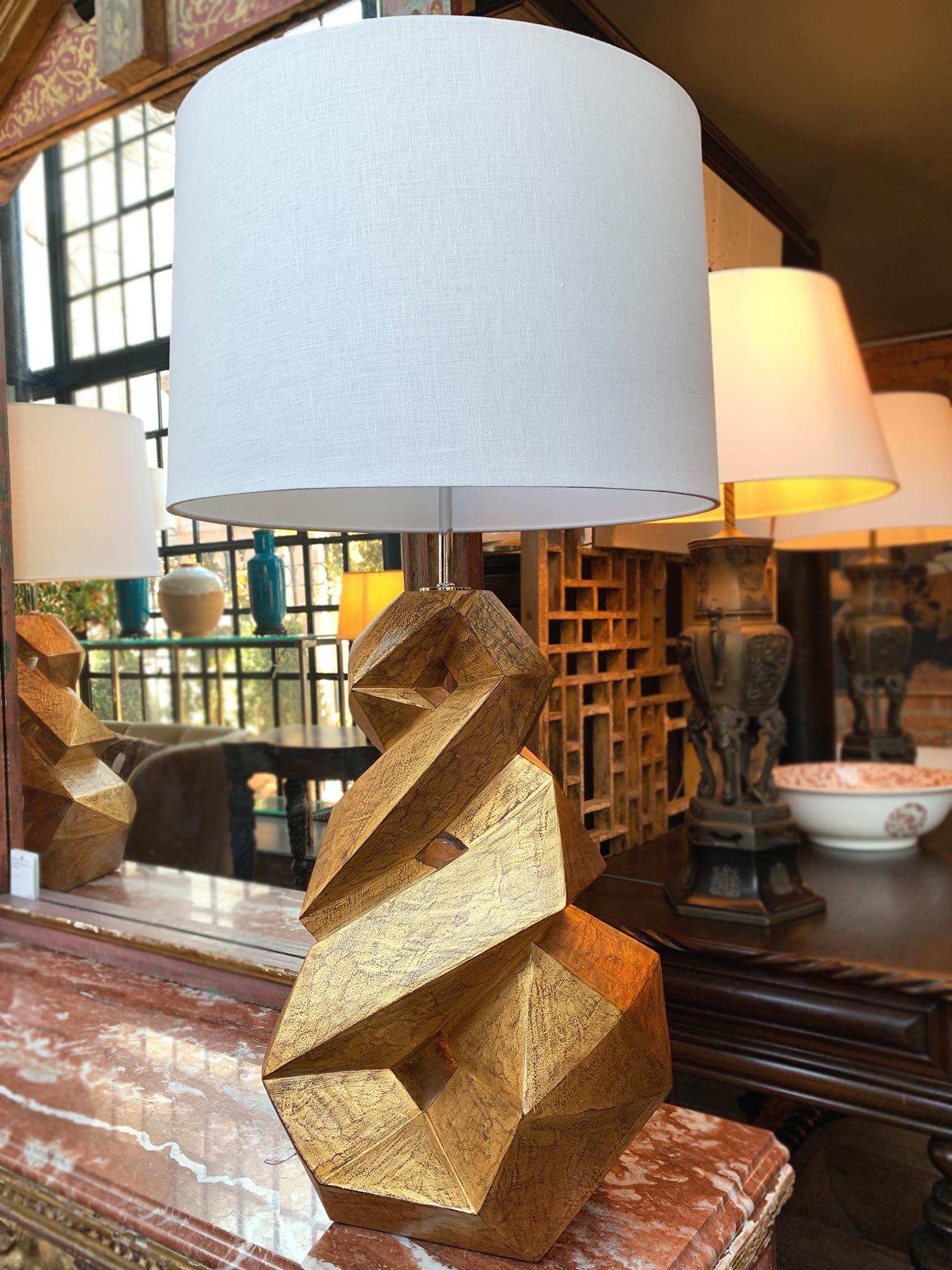 These Christopher Guy table lamps are hand-sculpted solid mahogany wood in a gold finish with chrome hardware. With their dynamic helix form and bold color, they are both a great source of lighting and undeniable statement pieces. The lamps are