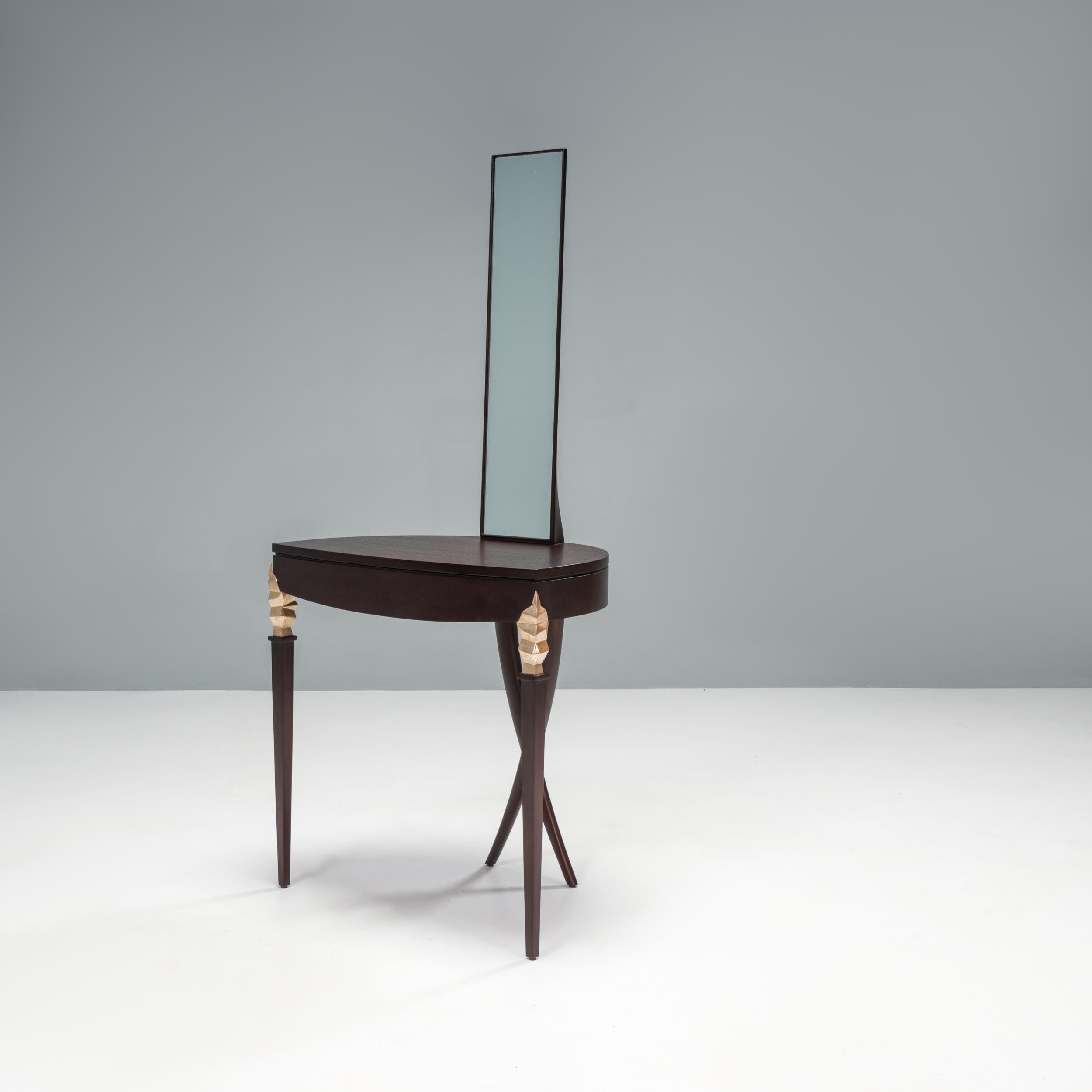 Designed by Christoper Guy and manufactured by skilled artisans in Indonesia, this Statuesque vanity table is inspired by the Art Deco era.

Constructed from hand carved mahogany wood, the table features tapered legs with engraved detailing at the