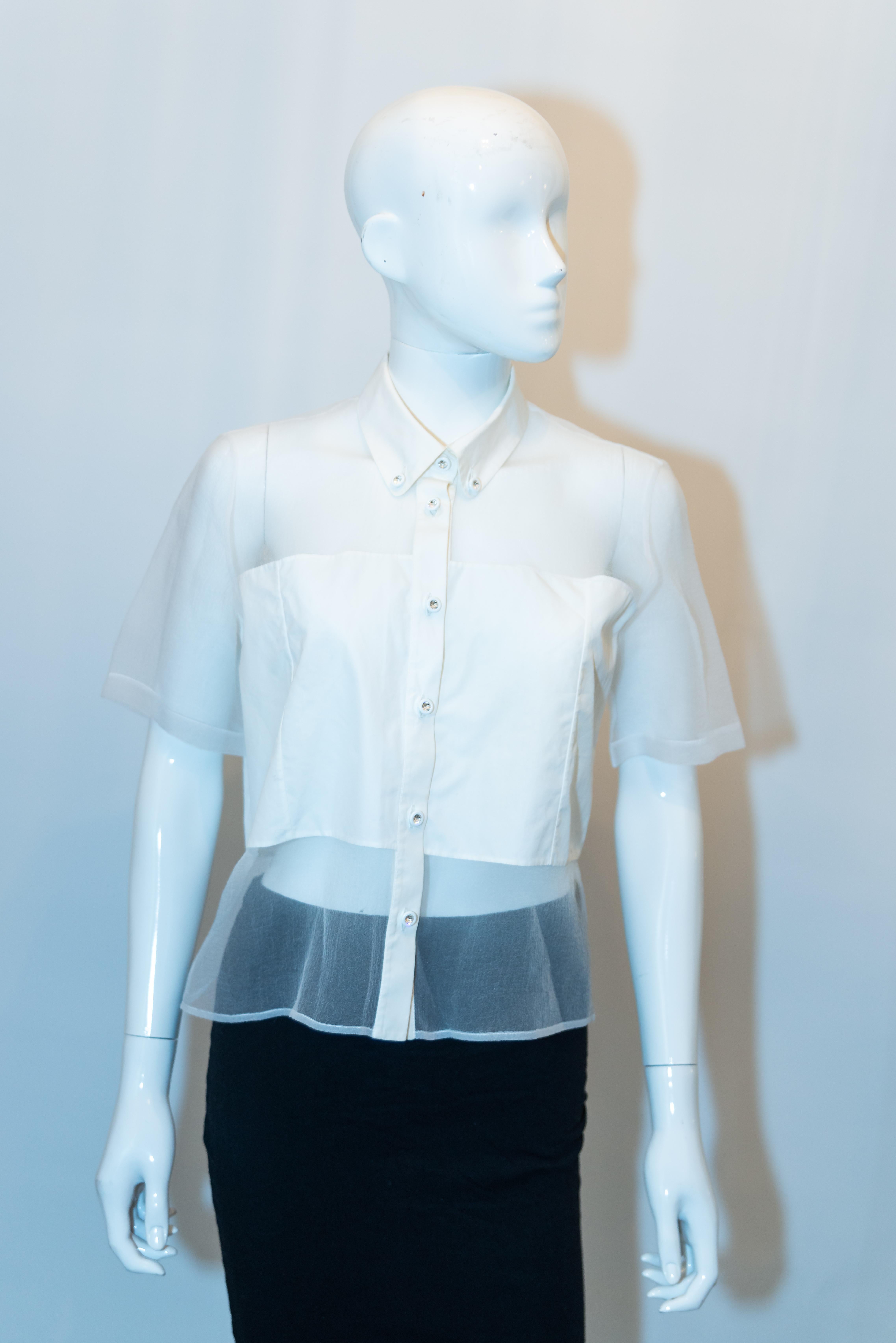 Une chemise chic de Christopher Kane, ligne principale. La chemise blanche a des panneaux transparents et une ouverture sur le devant avec des boutons Swarovski. Fabriqué en Italie, taille UK 12, EU 40.
Mesures : Poitrine jusqu'à 39'', longueur 21''