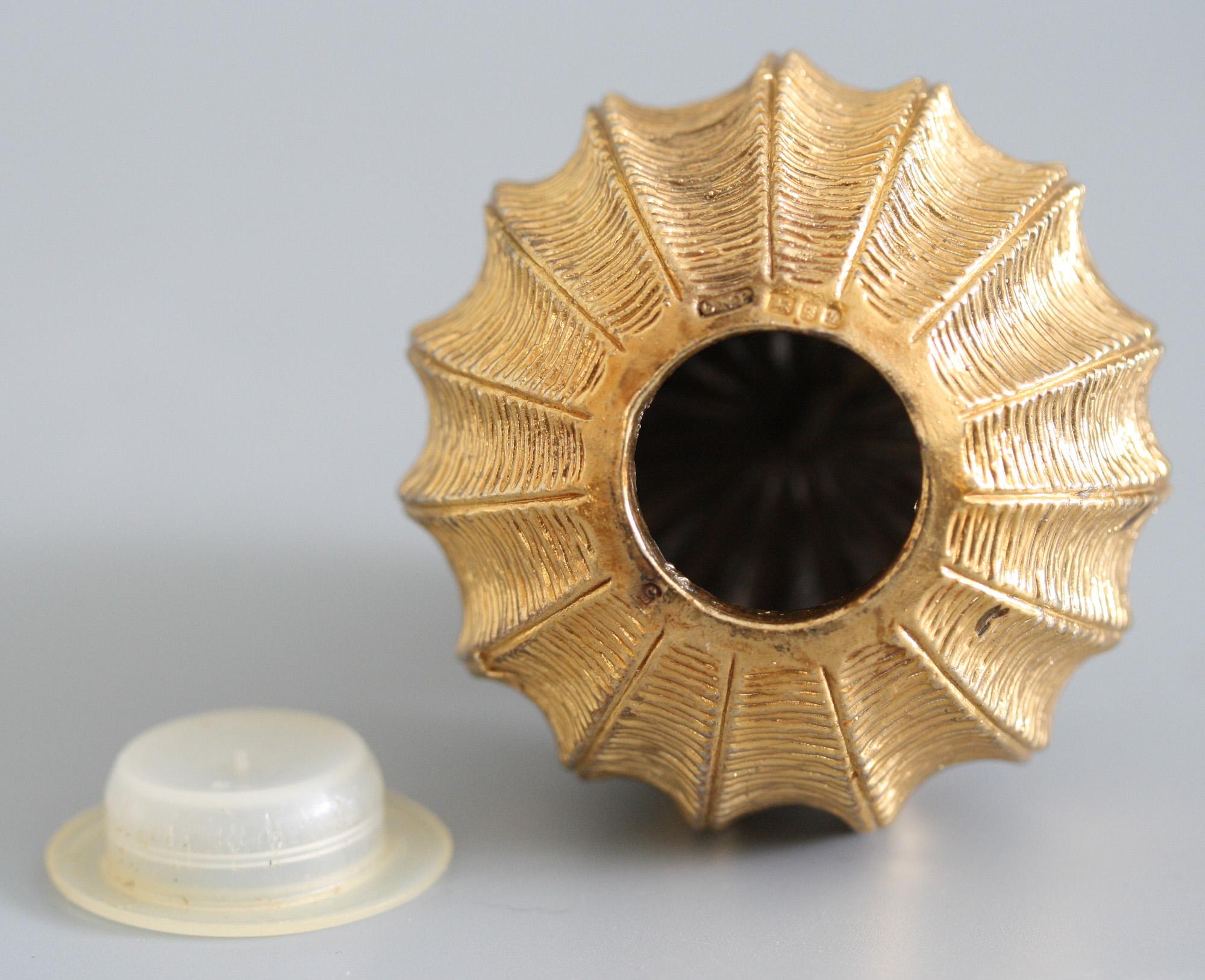 A finely made vintage silver gilt pomander applied with flowers with blue cabouchon centres designed by Christopher Lawrence, London and with silver assay marks for 1982. The urchin shaped rounded pomander has a filler hole to the base and has a