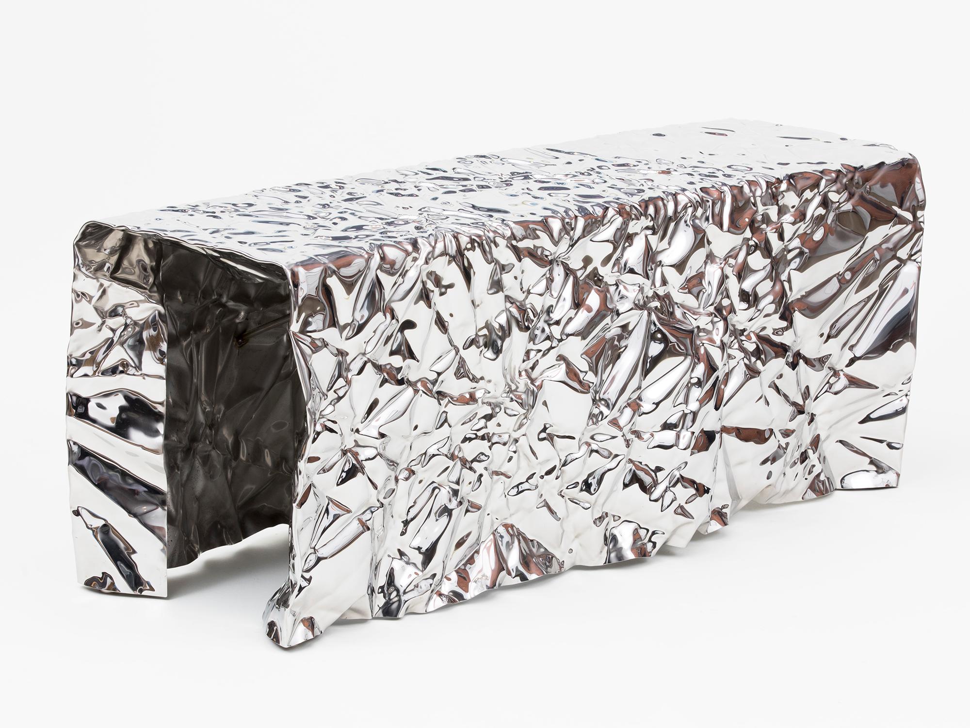 Wrinkled steel bench with a mirror-polished finish by Omaha-based designer Christopher Prinz, who achieves this unusual texture by repeatedly creasing a thin sheet of steel, resulting in a strong, rigid, and unique form. Adapted from an automotive