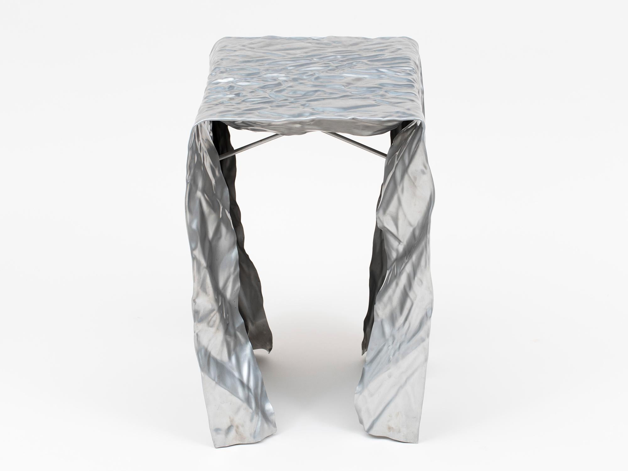 Wrinkled brushed stainless steel stool by Omaha-based designer Christopher Prinz. Can be used indoors or outside. 1 currently available. Lead time for additional and made-to-order custom works is 6-8 weeks. Available in a range of raw and polished