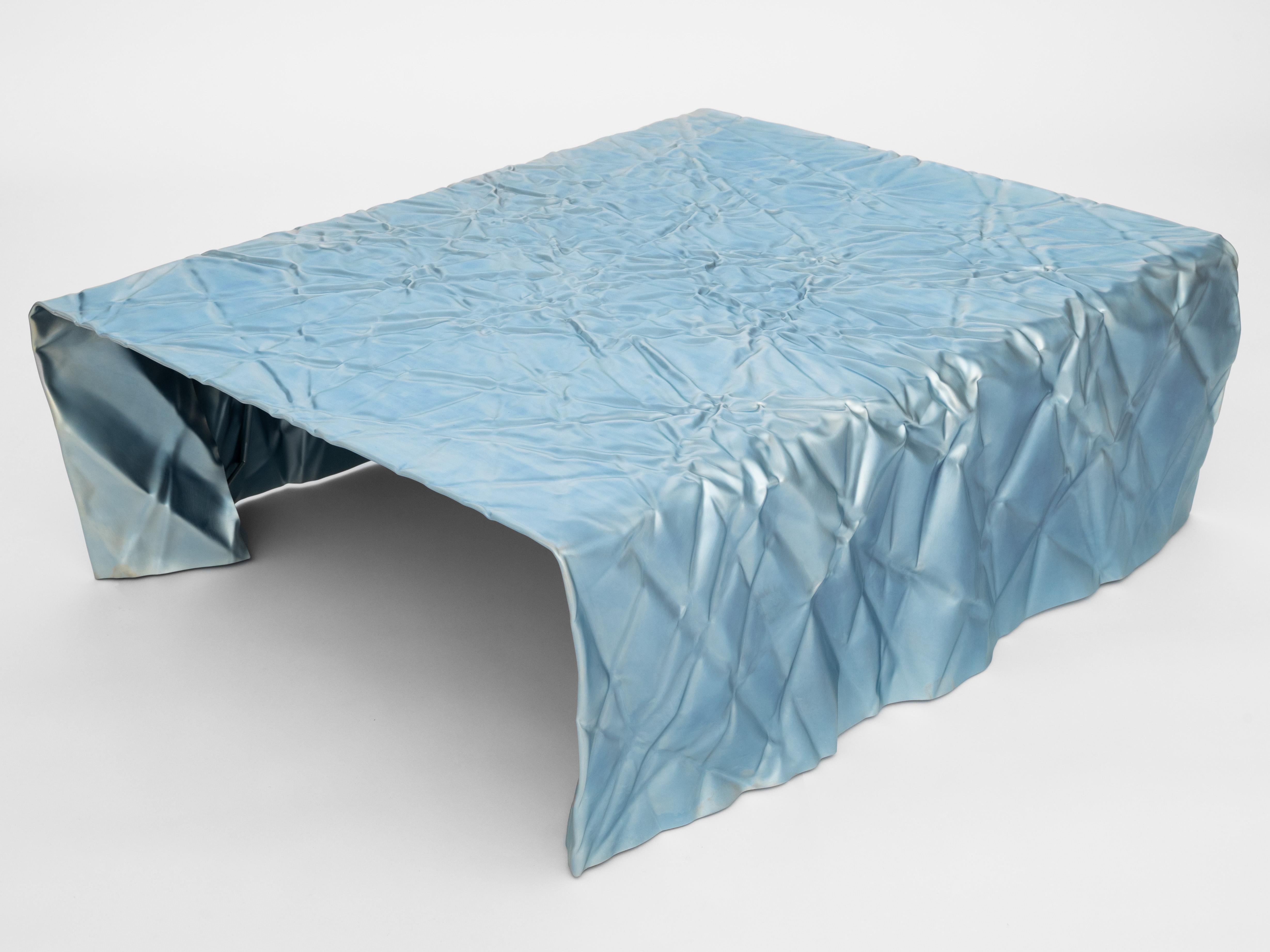 Wrinkled steel coffee table by Omaha-based designer Christopher Prinz, who achieves this unusual texture by repeatedly creasing a thin sheet of steel, resulting in a strong, rigid, and unique form. Hidden leveling feet protect surfaces and ensure