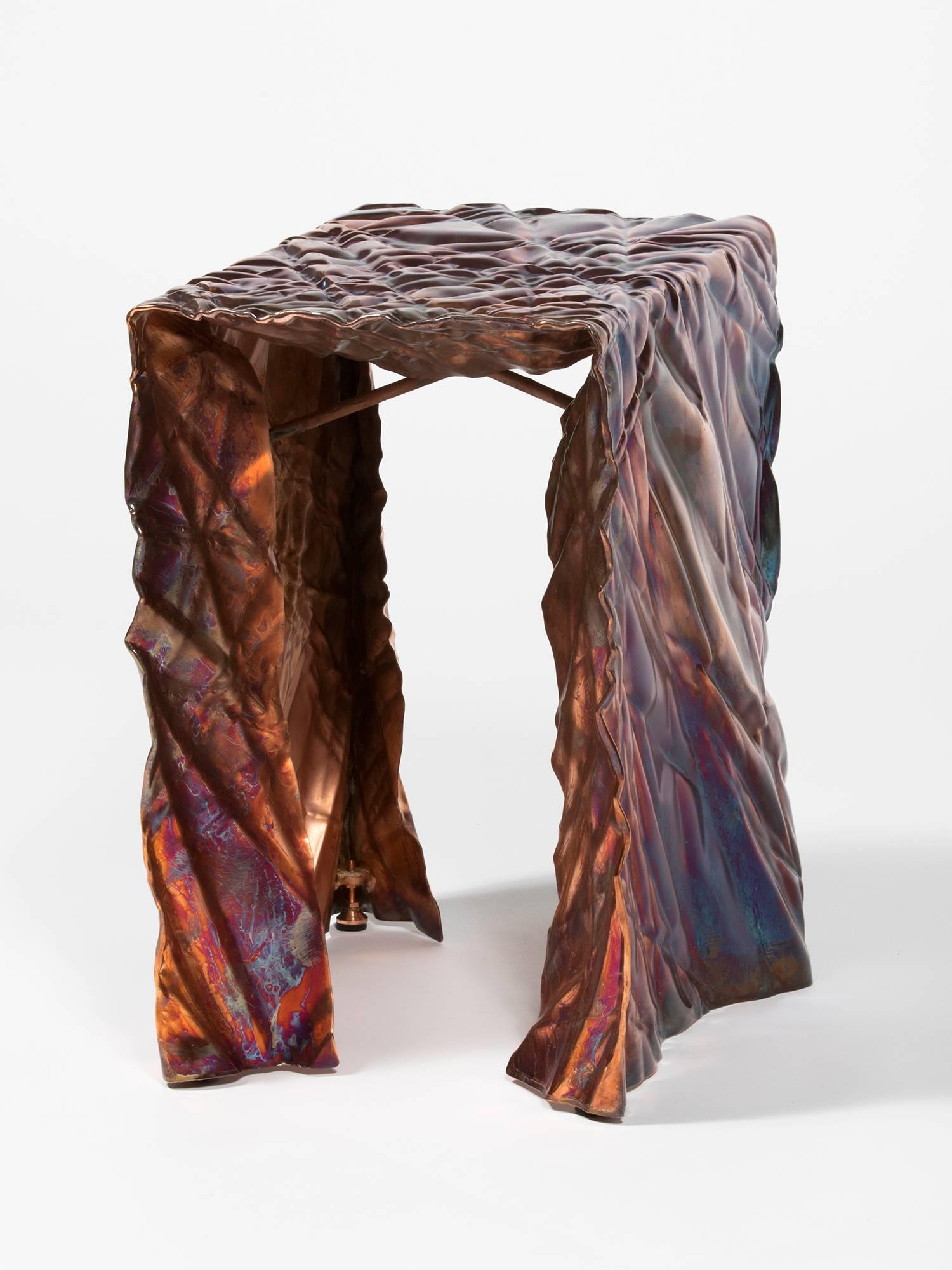 Wrinkled stool in living copper by Omaha-based designer Christopher Prinz, who achieves this unusual texture by repeatedly creasing a thin sheet of steel, resulting in a strong, rigid, and unique form. Hidden leveling feet protect surfaces and