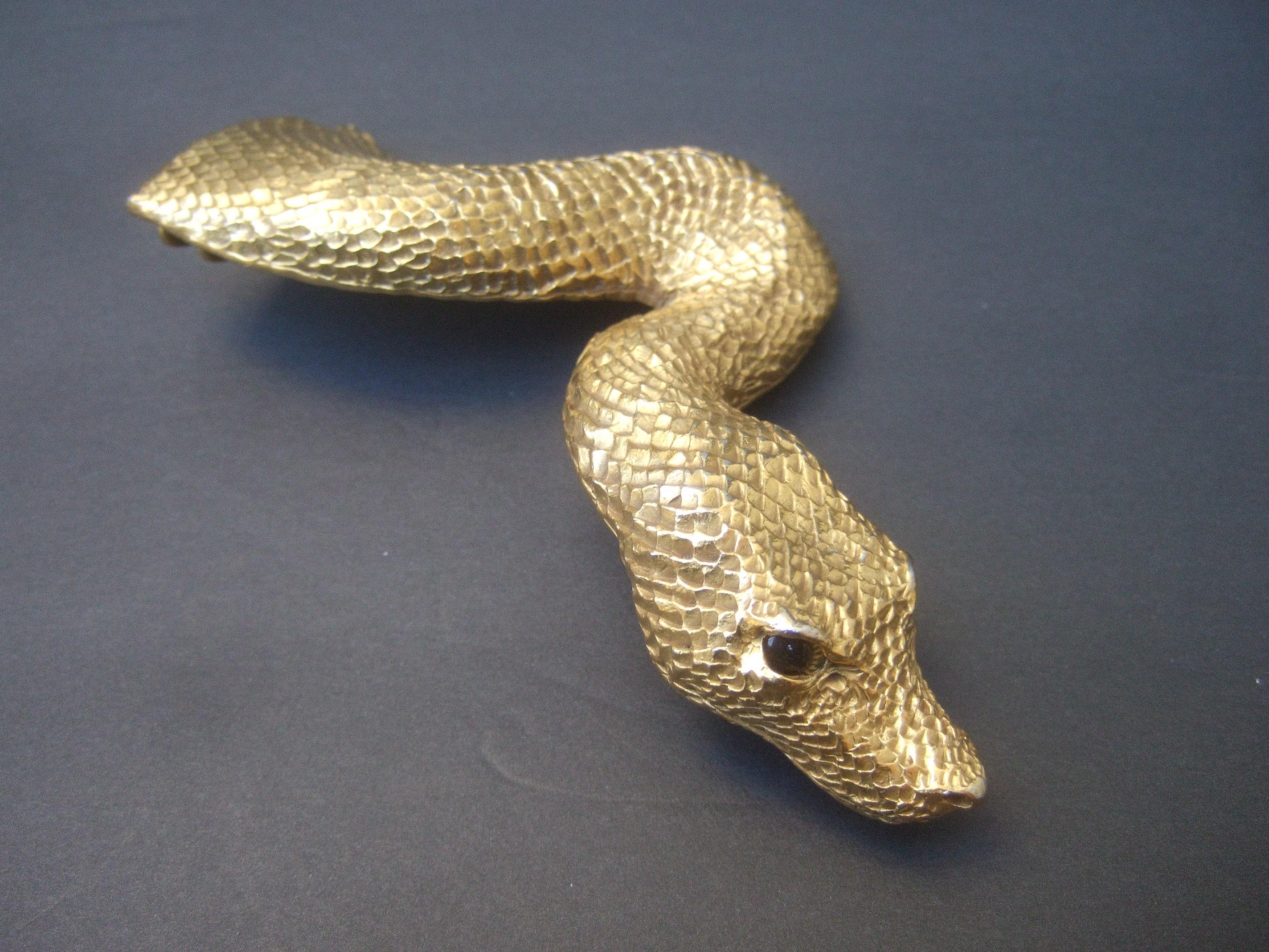 Christopher Ross 24k gold plated serpent belt buckle c 1980
The avant-garde belt buckle is designed in the likeness 
 of a large scale serpent figure

The luminous 24k gold plating has an etched impressed detail that emulates scales. The piercing