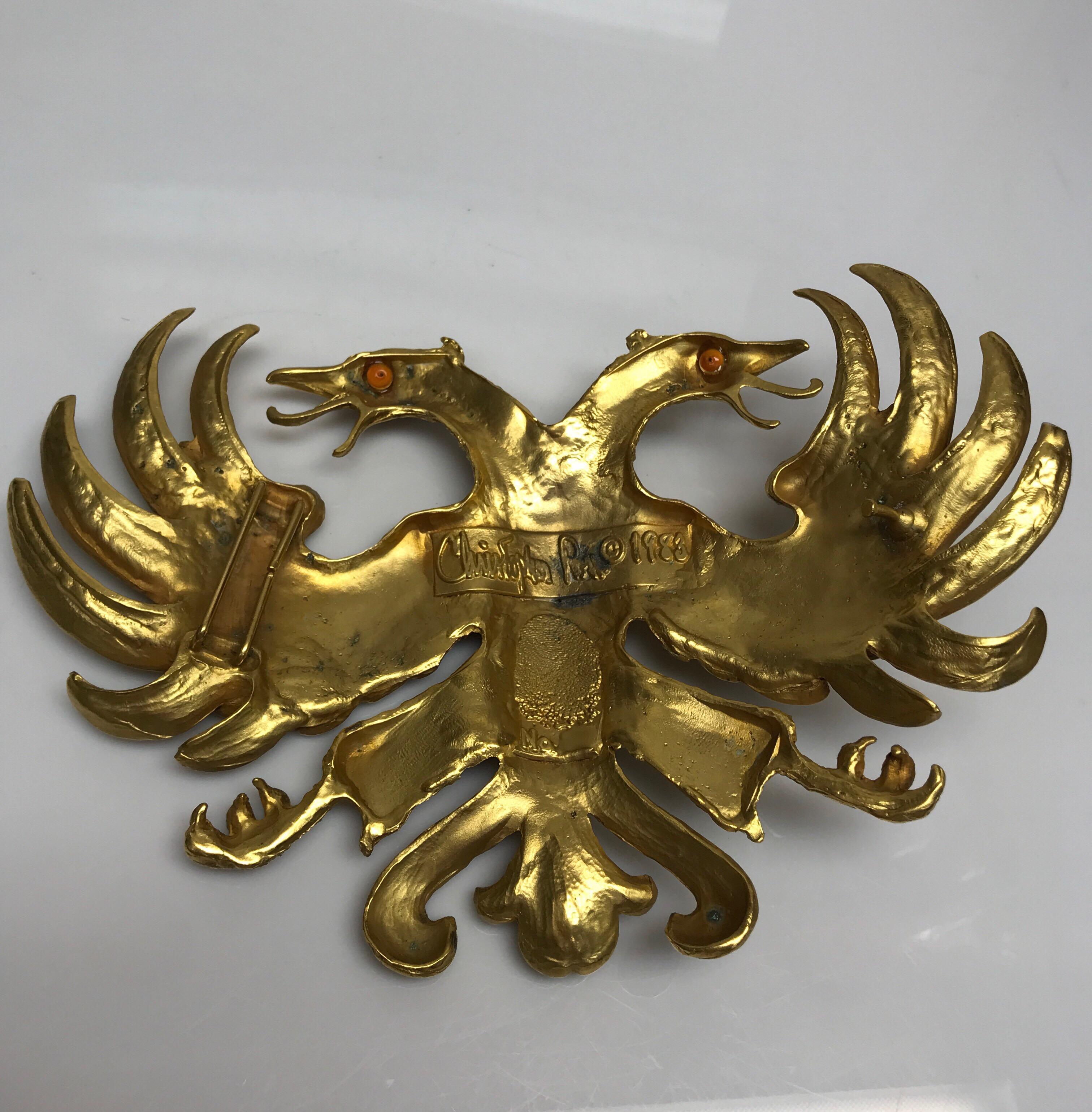 Christopher Ross Gold Large Double Bird Buckles 1983. This vintage Christopher Ross belt buckle is in good condition. The gold shows chips or wear throughout, as shown in pictures. This piece is two large birds with a large wingspan. Belt is sold