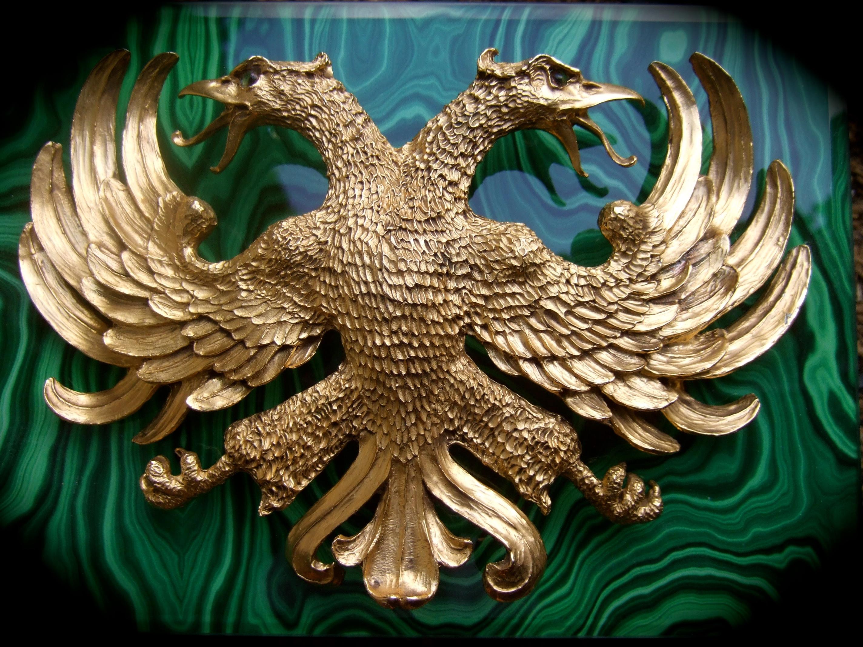 CHRISTOPHER ROSS Massive 24k vergoldete doppelköpfige Adler-Gürtelschnalle um 1983 
Die riesige, handgefertigte Gürtelschnalle ist mit einem Adlerpaar gestaltet, das 
aus leuchtendem 24-karätigem Gold. Die große Flügelspannweite vermittelt die