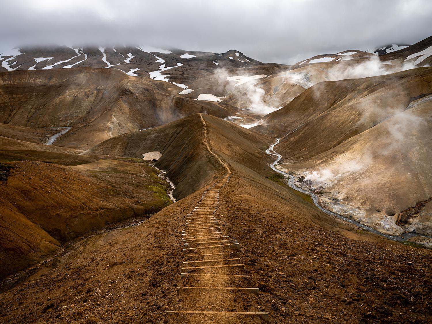 These young mountains overlook the Icelandic Highland region's Kerlingarfjöll geothermal volcanic system of hissing fumaroles, spitting hot vents, and steaming geysers. 25-35mph gusts further emphasize the terrestrial orifices from which the Earth
