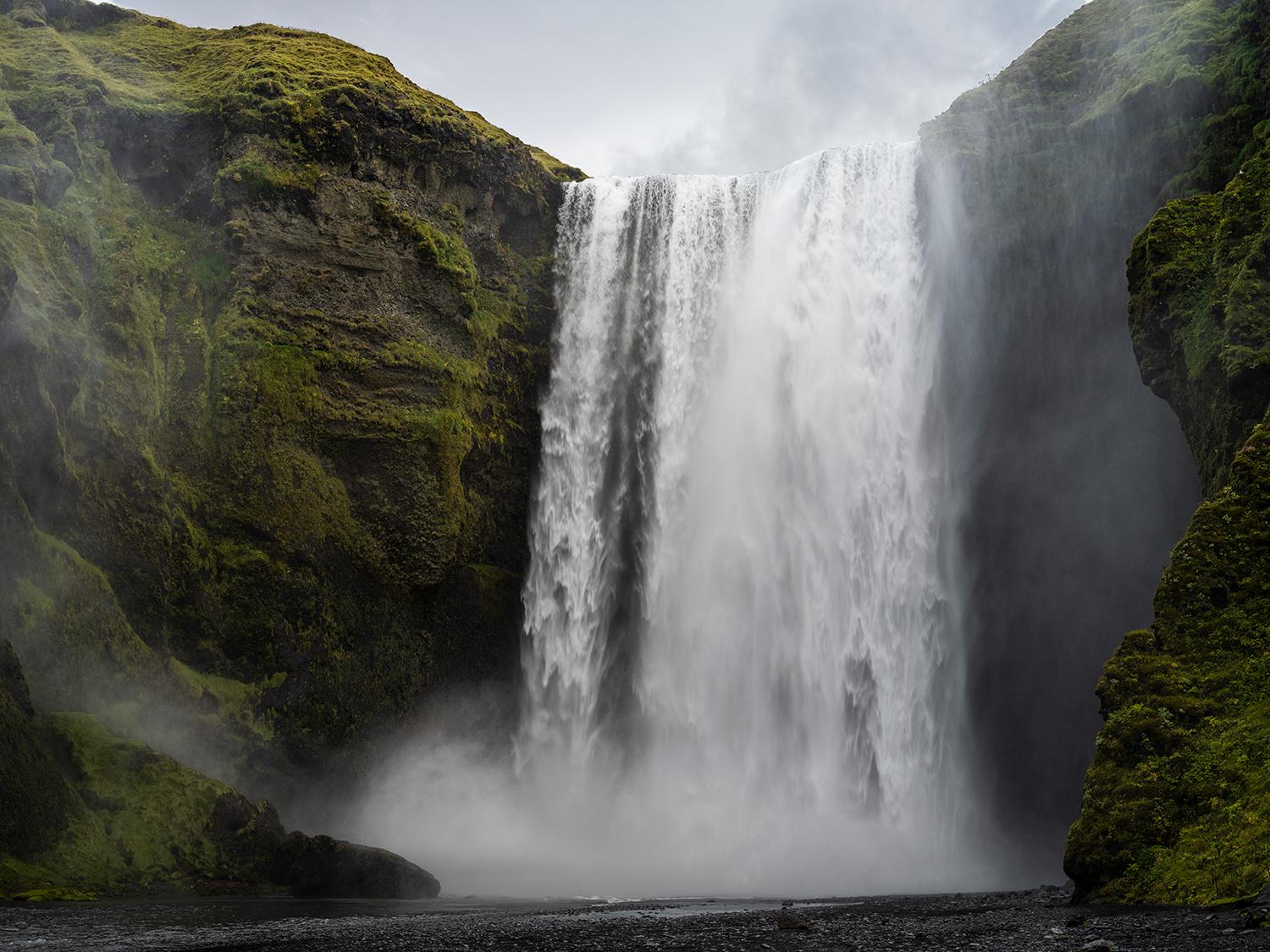 Aus grünen Moosrändern ragen vulkanische Klippen an der isländischen Küste empor, die von gewundenen Pfaden aus losem Kies gesäumt sind, die sich nach unten schlängeln.

Reihe: Ísland
Archiv-Pigment-Platin-Druck	
Alle verfügbaren Größen und