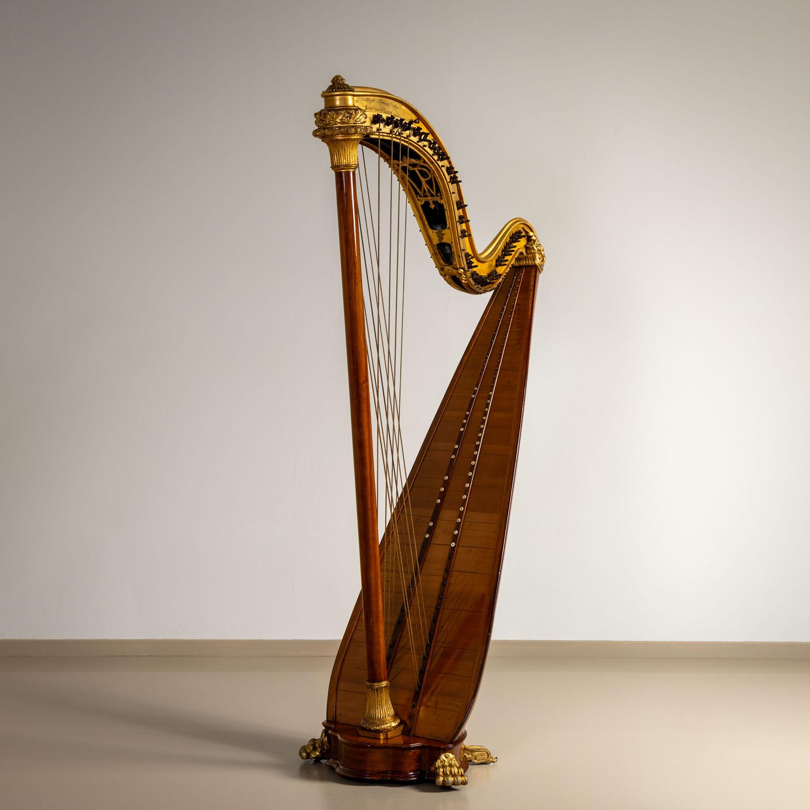 Large double harp with gold-patinated head and neck and carved paw feet on the base. The harp is marked on the neck 