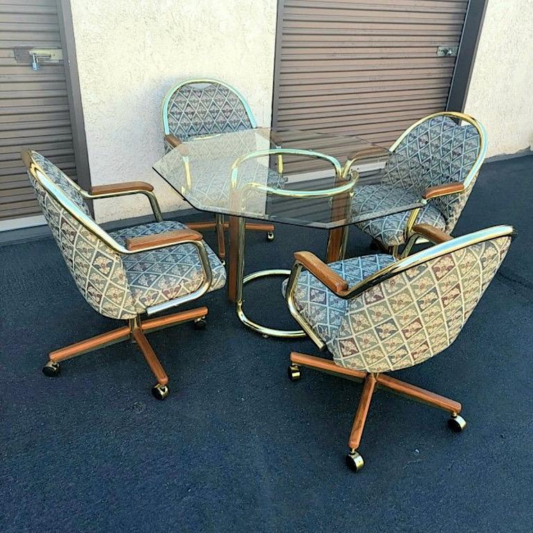 This listing is for a vintage 1990s dining set by Chromcraft furniture. This set includes an octagon beveled glass tabletop on an oak and gold plated tubular pedestal base and 4 fabric chairs on casters. The chairs have oak armrests and feature oak