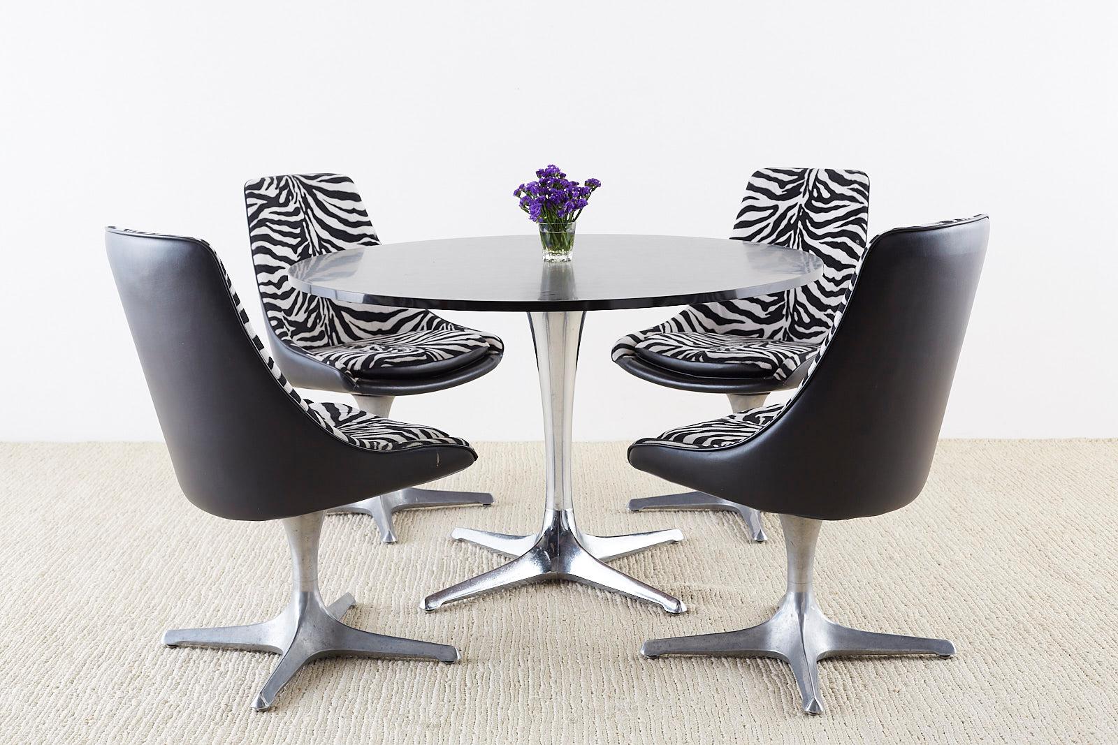 Iconic Mid-Century Modern dining table featuring a large tulip-formed polished aluminium column base. Mady by Chromcraft from their decorables collection circa 1968. Large round laminate top with a black formica surface. The table is supported by a