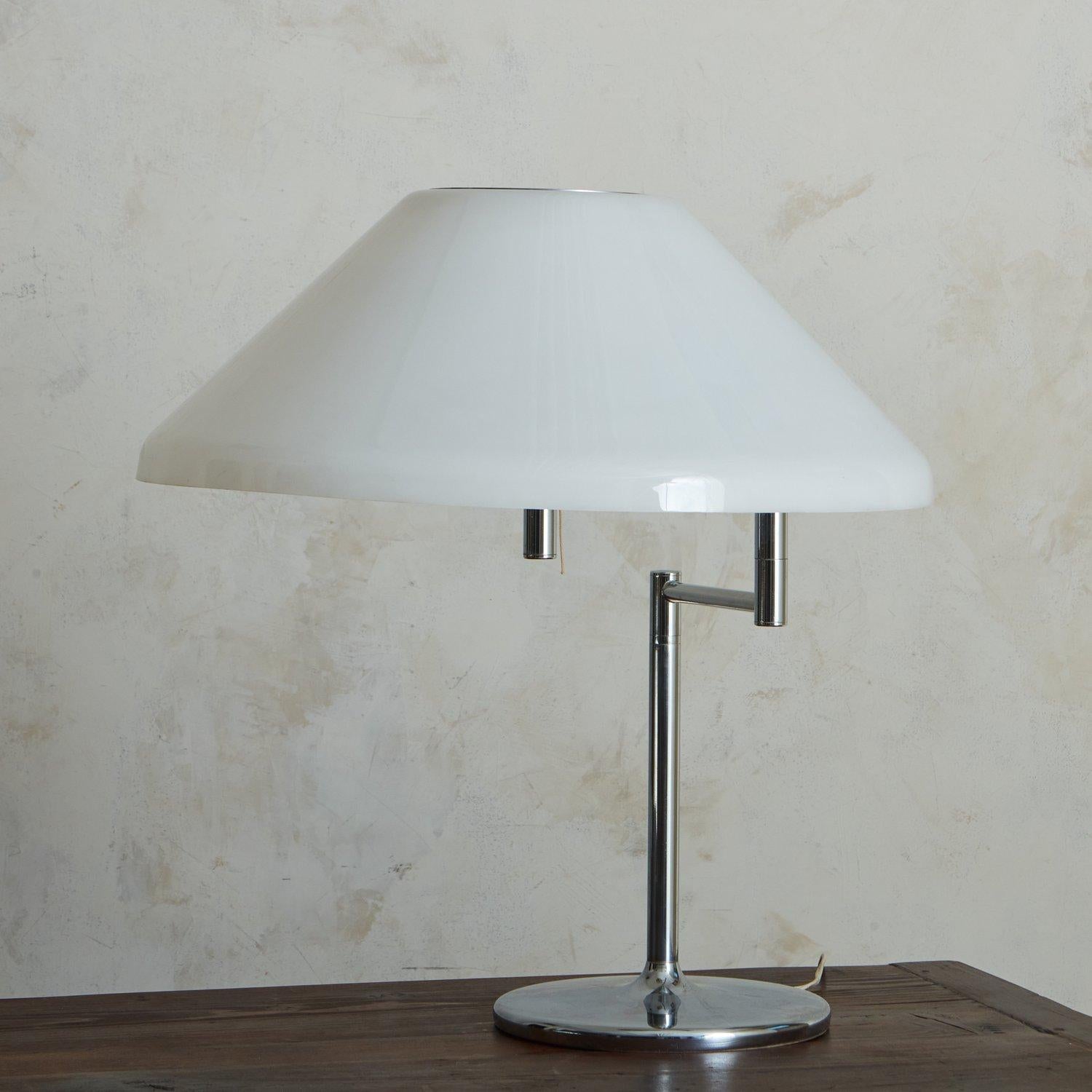 A 1960s table lamp attributed to Swiss Lamps International. This lamp features a chrome frame with a circular base and a pivoting arm, which supports a white acrylic shade. Unmarked. Sourced in France, 1960s. 

DIMENSIONS: 10