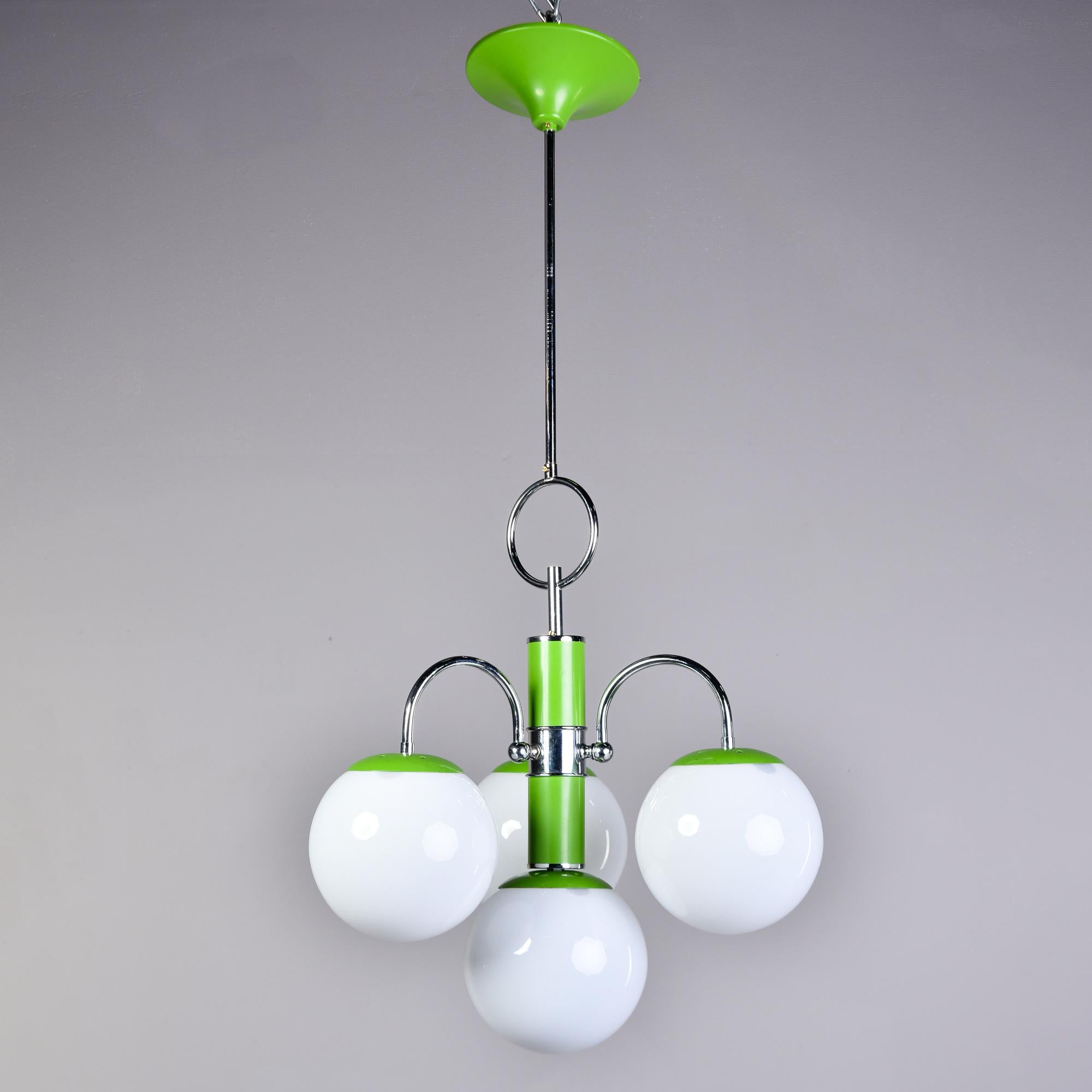 Found in Italy, this four light fixture dates from the early 1970s. Polished chrome frame with apple green enamel accents and four white glass globes. Each globe has a single internal standard sized light socket. Wiring has been updated for US