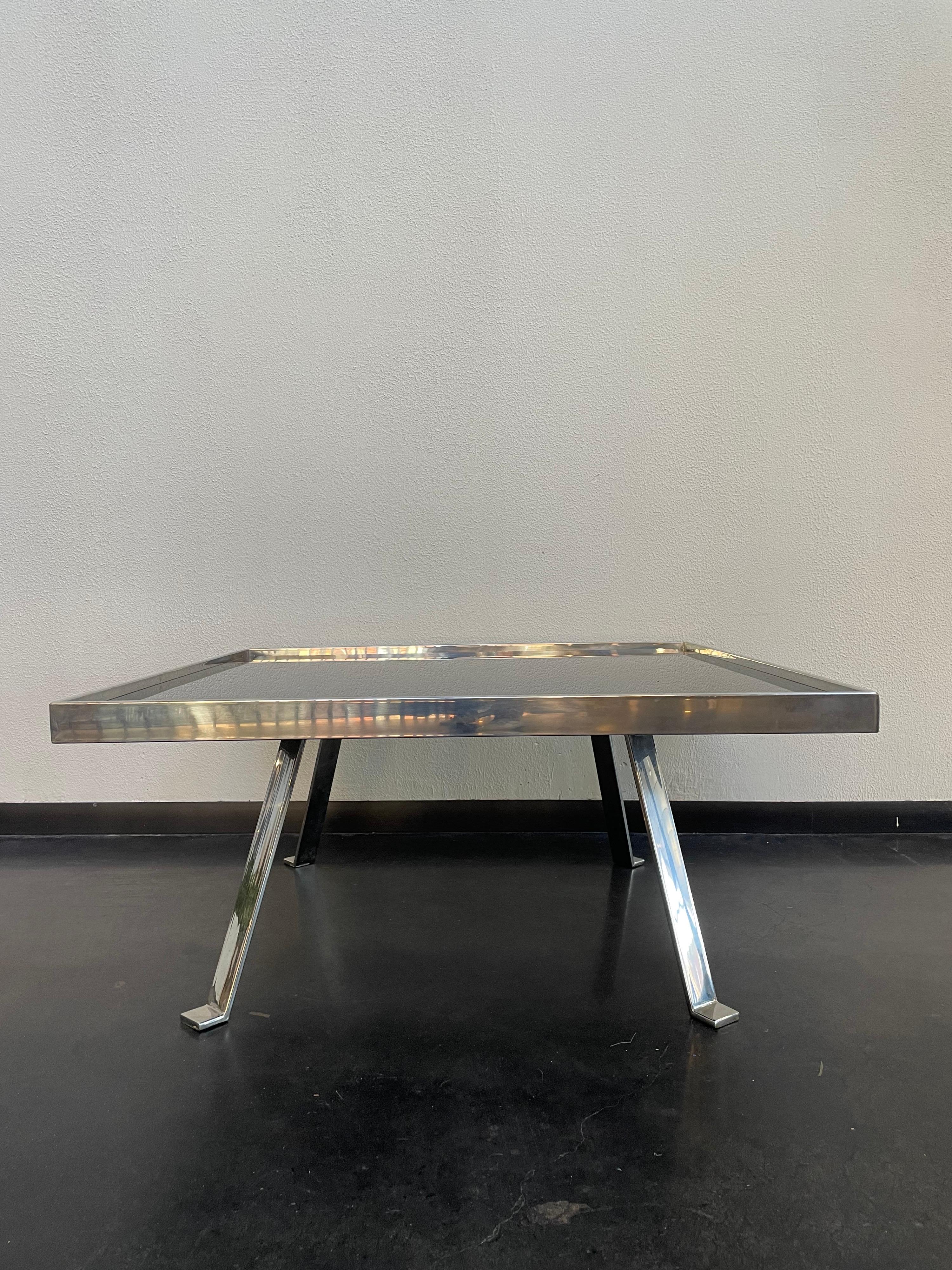 Chrome and black glass cocktail table, of square form with inset black glass, raised on four flat bar legs.