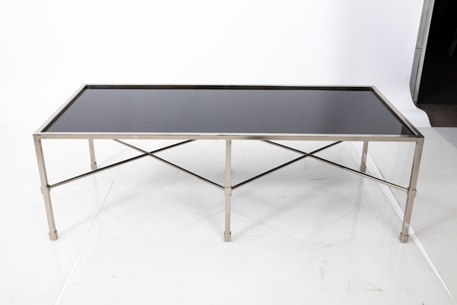 Chrome and black glass coffee table with double X-frame base in a polished finish, circa 1990s. Please note of wear consistent with age including minor pitting to the Chrome. Made in the United States.