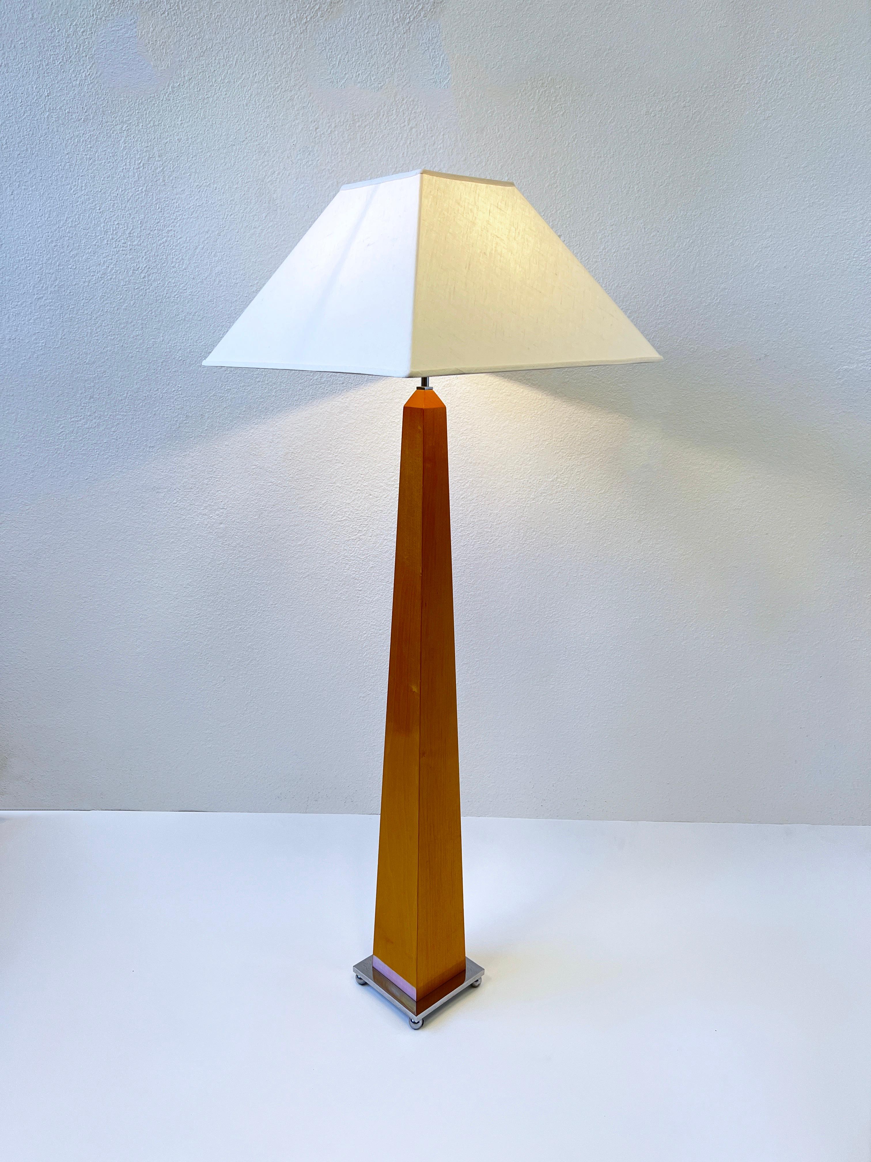 Blond wood and polish chrome obelisk shape floor lamp from the 1980’s. 
Newly rewired and new vanilla linen shade. It takes one 100w max Edison lightbulb. 
Measurements: 7” wide, 7” deep 55.5” high. 
Shade is 20” wide 20” deep. 45.5” high to