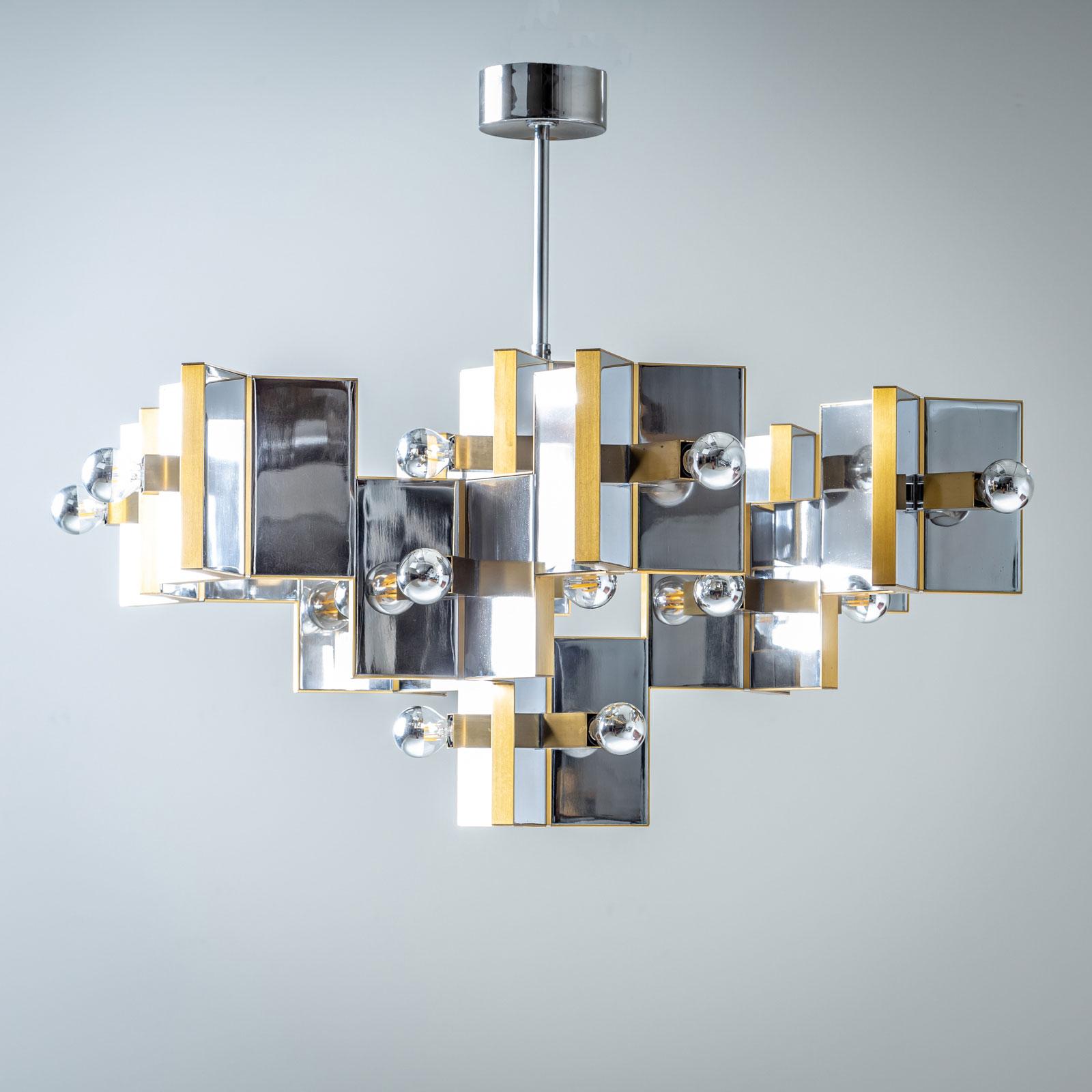 Grande lampadario in cromo lucido e ottone, disegnato da Gaetano Sciolari negli anni '70. Il lampadario è composto da dischi rettangolari in una disposizione geometrica a nido d'ape.