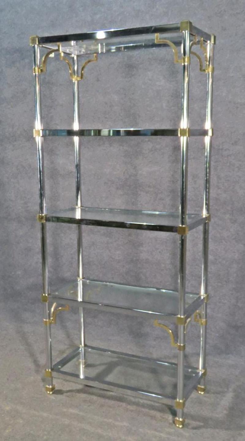 This is a gorgeous and iconic design. The chrome and brass etagere is in good condition with normal age related wear and oxidation to brass which can be polished as well as the chrome. Chrome and brass frame. 5 glass shelves. Measures: 71 3/4