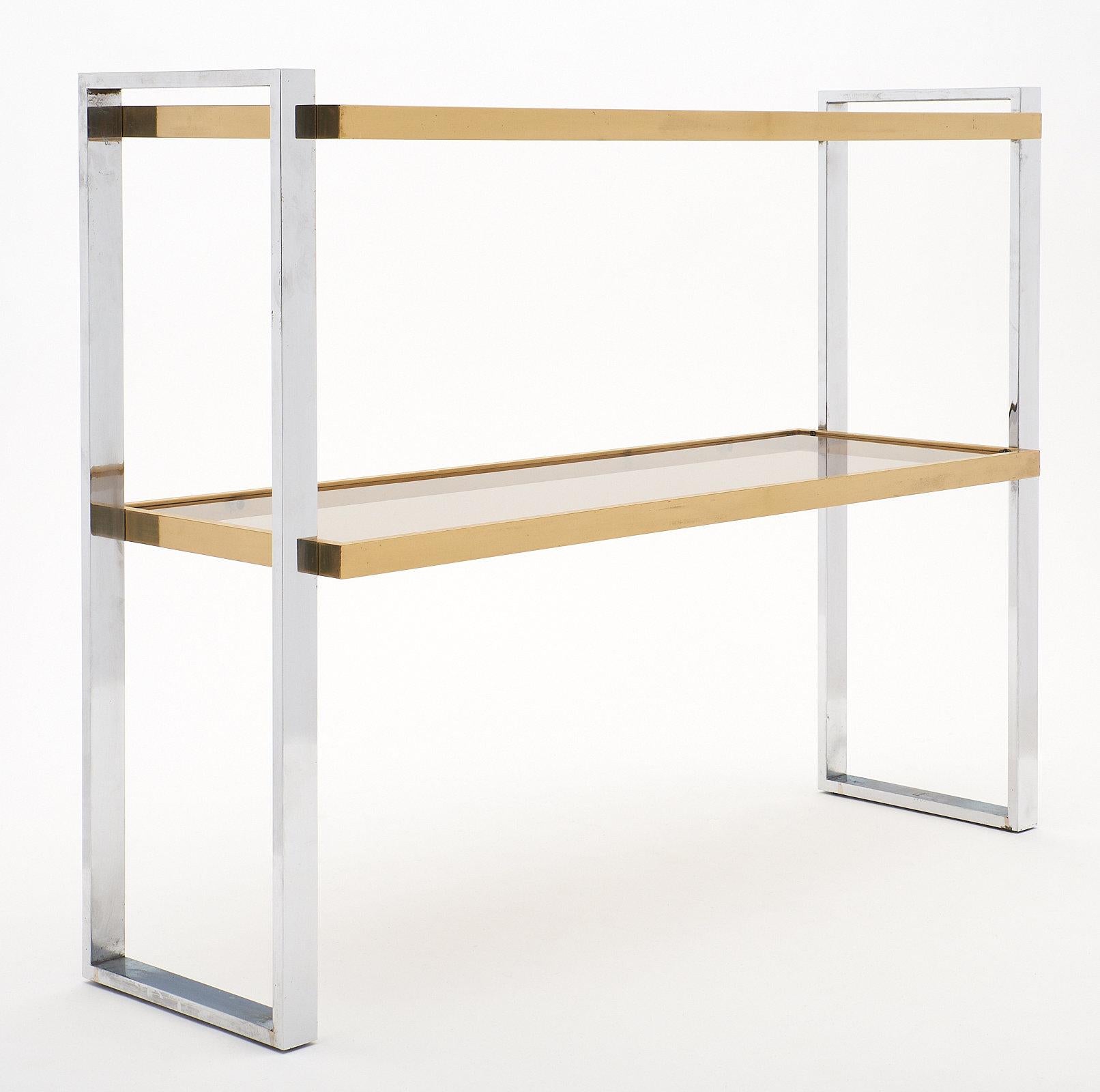 Italian chrome and brass console table attributed to Romeo Rega. This piece has a striking chrome frame with two smoked glass shelves, each supported by brass. We love the modernist design and strong presence of this console. It was purchased in