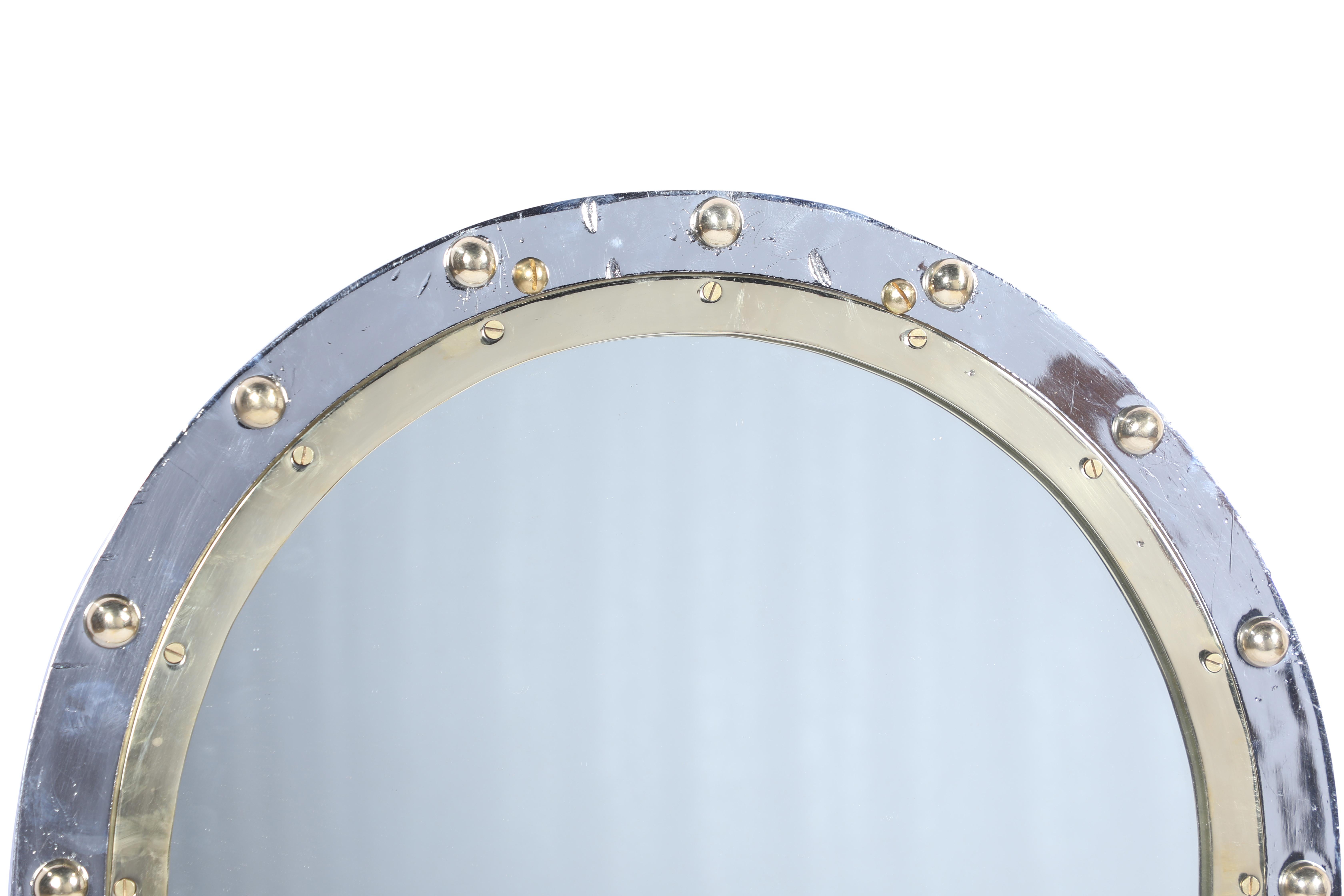 From a decommissioned ship, an oval fixed porthole window in a combination of chrome converted by us to a mirror. Classic styling. Rivets were added as these come out when taken off ships. Two brass supports on the back for hanging and metal back to