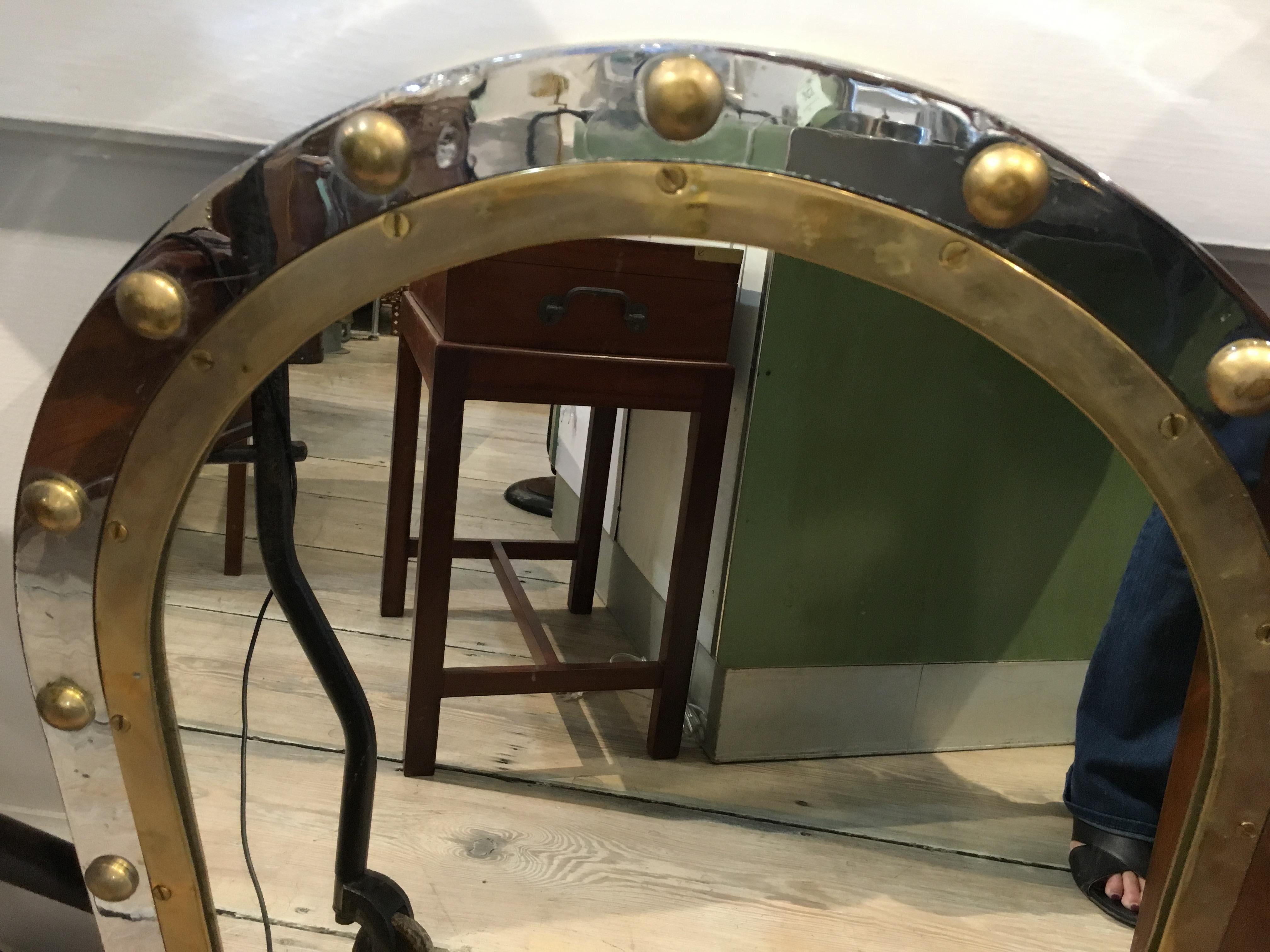 From a decommissioned ship, a combination of chrome and brass oval porthole window converted to a mirror. Classic styling. Rivets were added as these come out when taken off ships. Two brass supports On the back for hanging and wooden back to