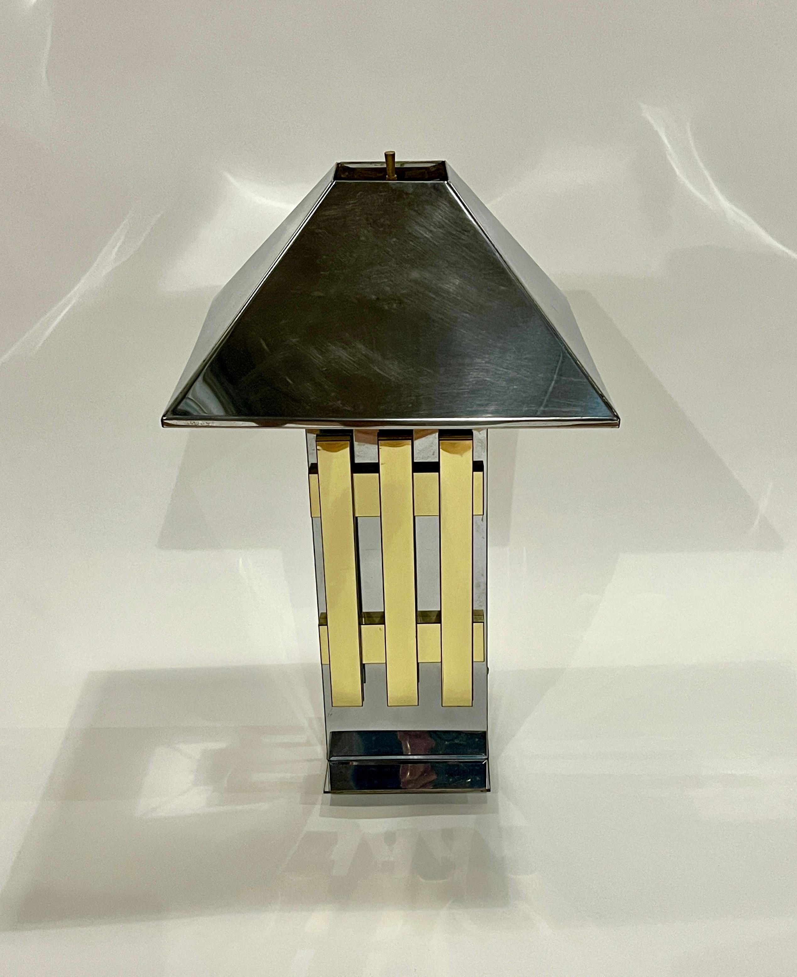 Sculptural mid-century modern table lamp made of chrome and brass with a metal shade in the style of Romeo Rega or Curtis Jere. Wired for US electricity and in working order. 