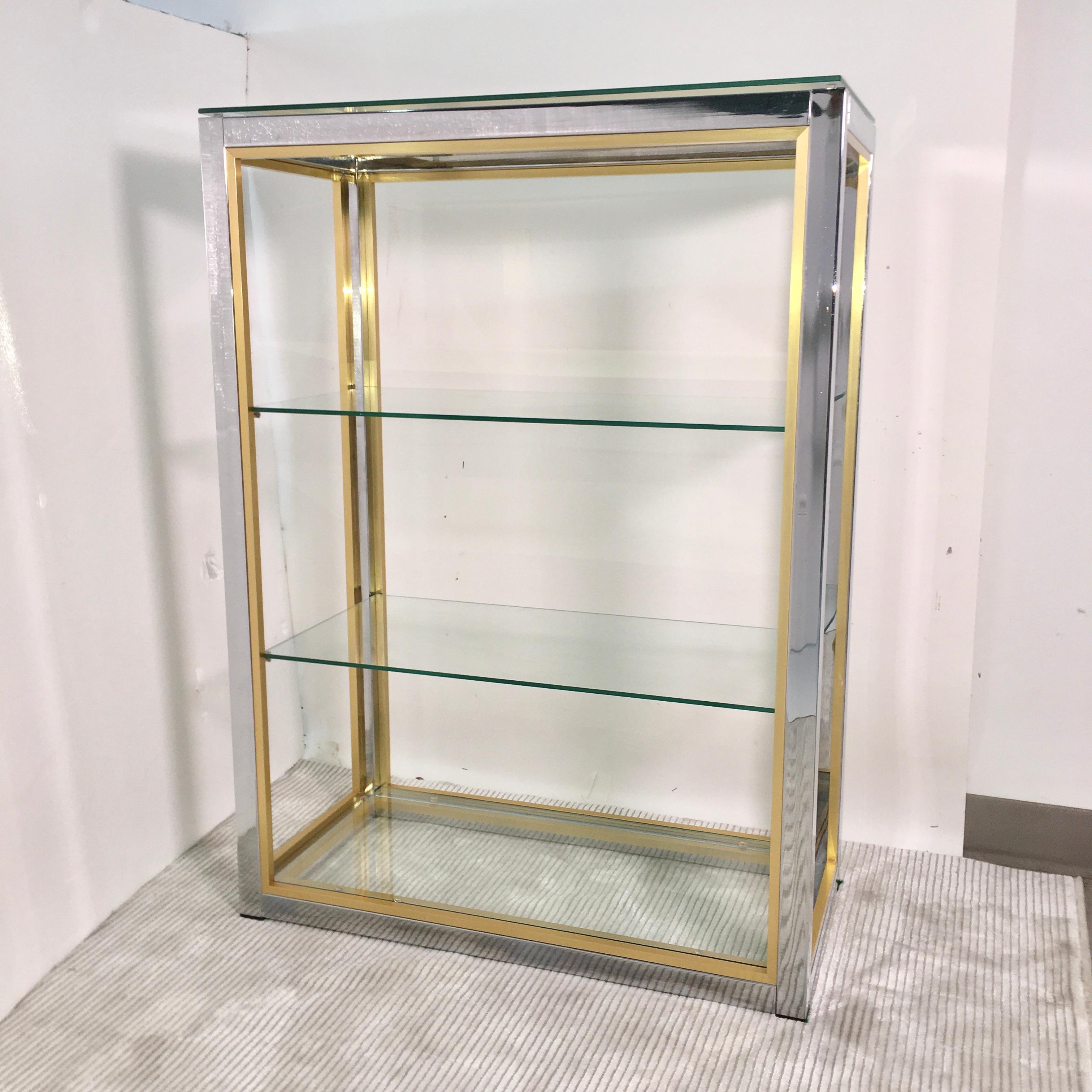 This is a chromed steel and brass trim small scale étagère, in the round, open from all sides, with four removable tempered safety glass shelves; two center, one floating on top and one bottom glass shelf inset within the floor.
~12 inches between