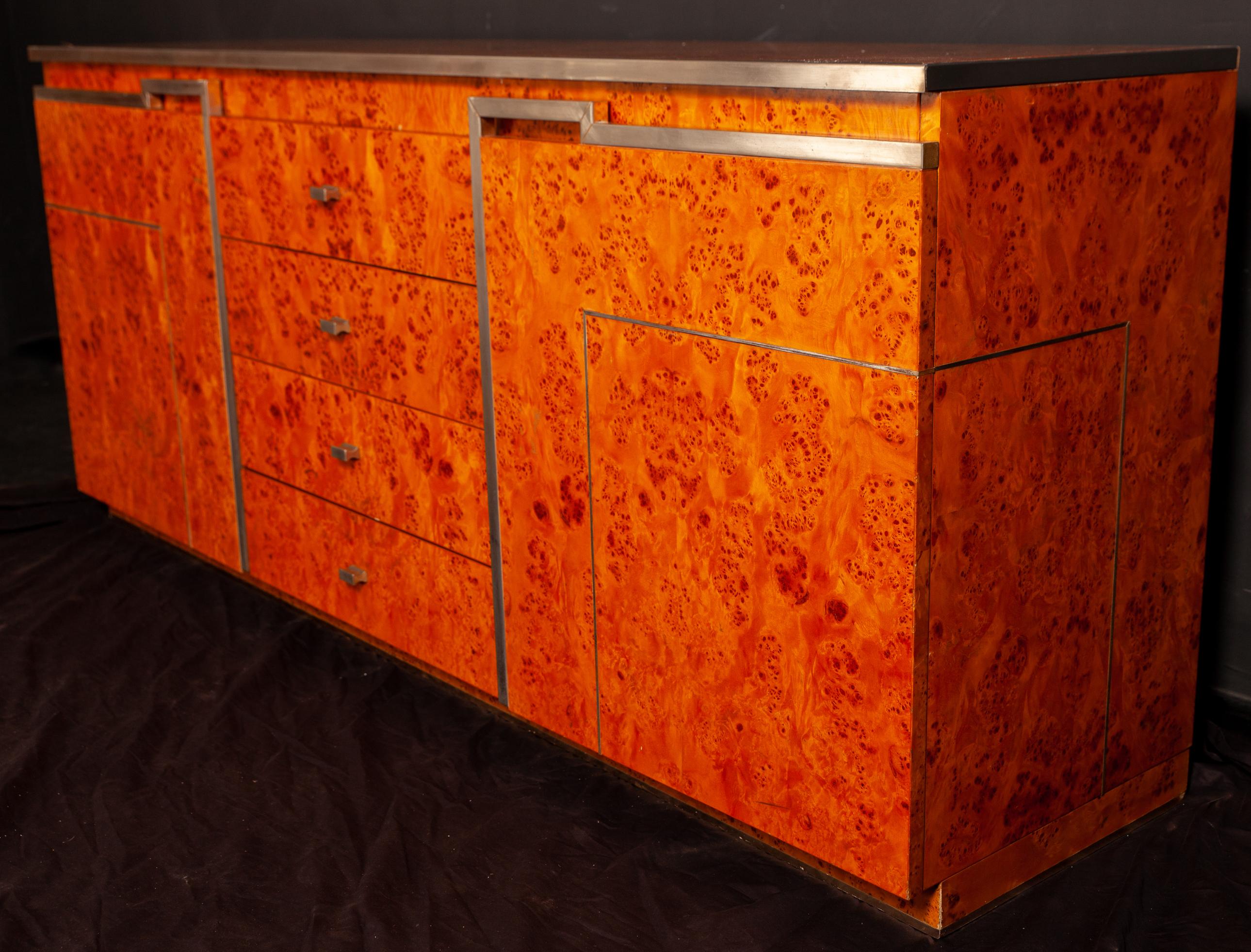 Fine burl wood rare credenza in the style of Willy Rizzo. The chrome accents, along the clean lines of the piece, serve to emphasize the richness of the wood as well as lend a subtle industrial touch. With four drawers in the center and two spacious