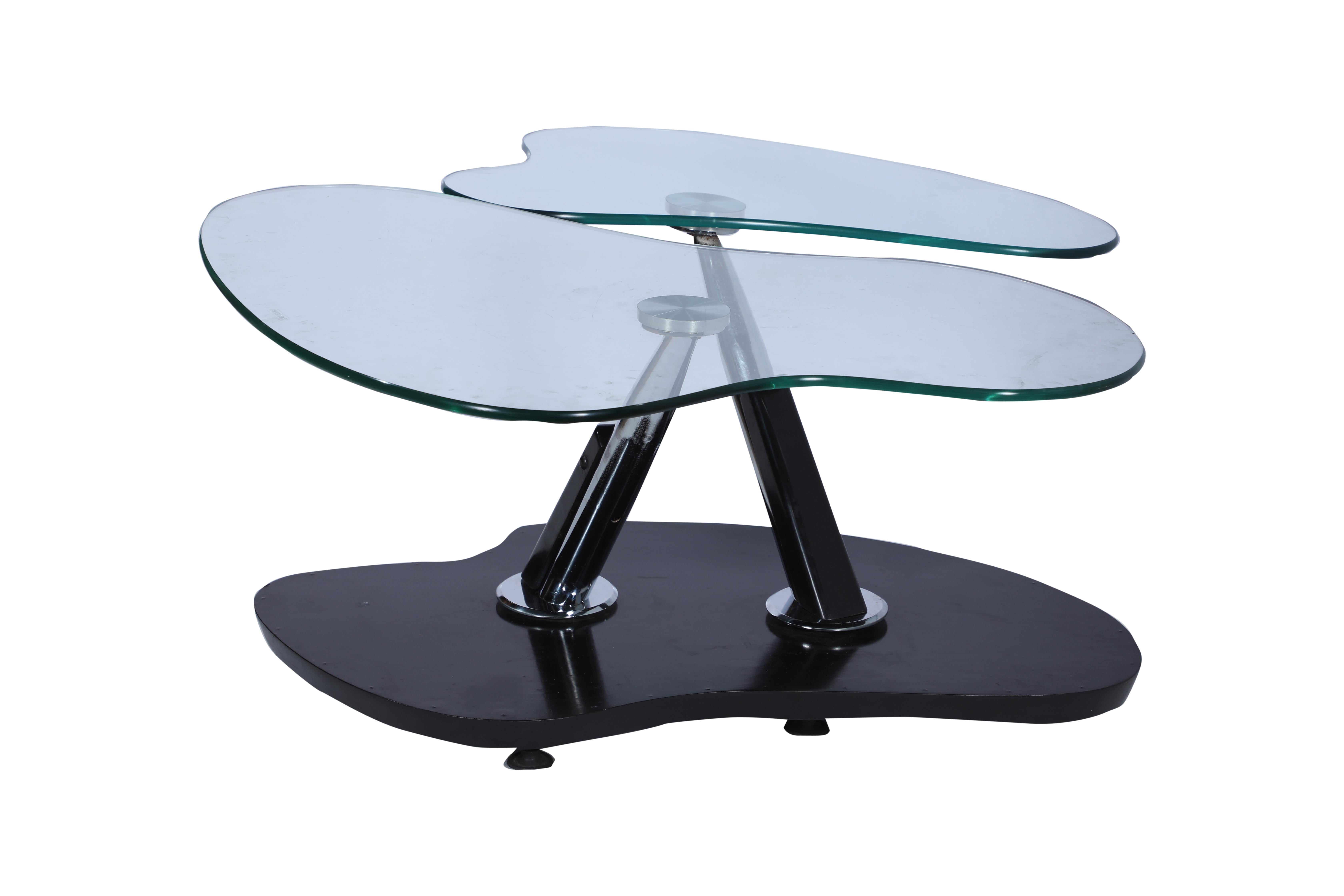 This table came from a decommissioned European cruise ship from the 1990's. It has an ebonized base and aesthetic ebonized supports over staggered and angled chrome legs, additional chrome details and two plate glass tops that swivel and overlap one