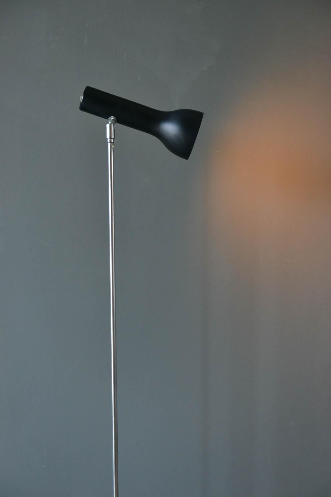 Chrome and enamel floor lamp by Lad Team for Swiss Lamps Int'l, circa 1960. Articulating and pivioting head with black enameled base and chrome stem. Original cord with original foot switch in good working condition. Base has some wear as shown,