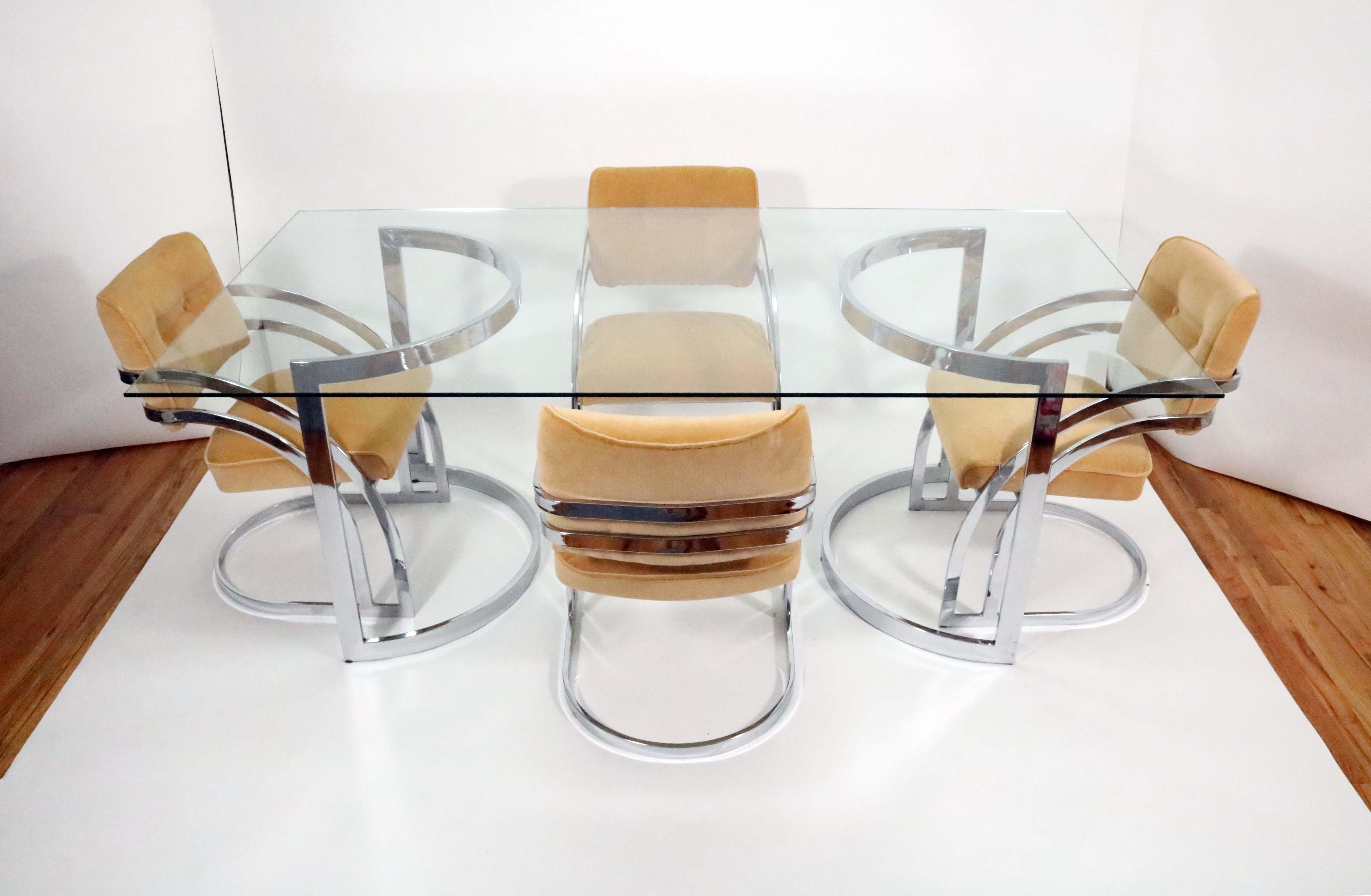A chromed steel and glass dining table and chrome and upholstered chairs by Cal-Style.

The glass top rests on a pair of crescent bases which can be configured to face inwards or outwards. 

Each base dimensions: 32