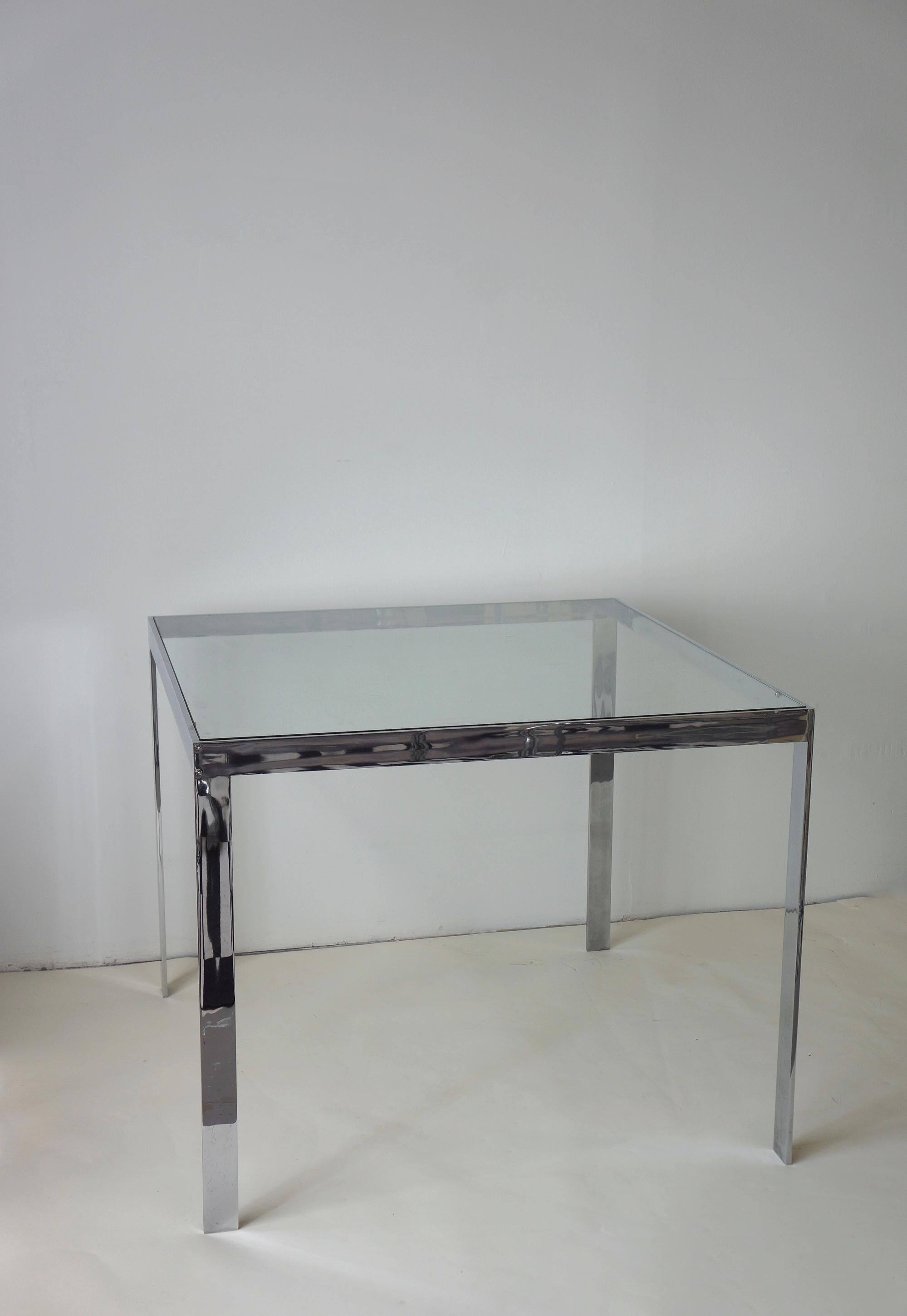 Elegante table de salle à manger carrée en verre et chrome. Il a été fabriqué dans les années 1970. Cette pièce minimale s'inscrit dans la lignée du design de l'époque. Le corps chromé solide et raffiné est construit de manière transparente. Les