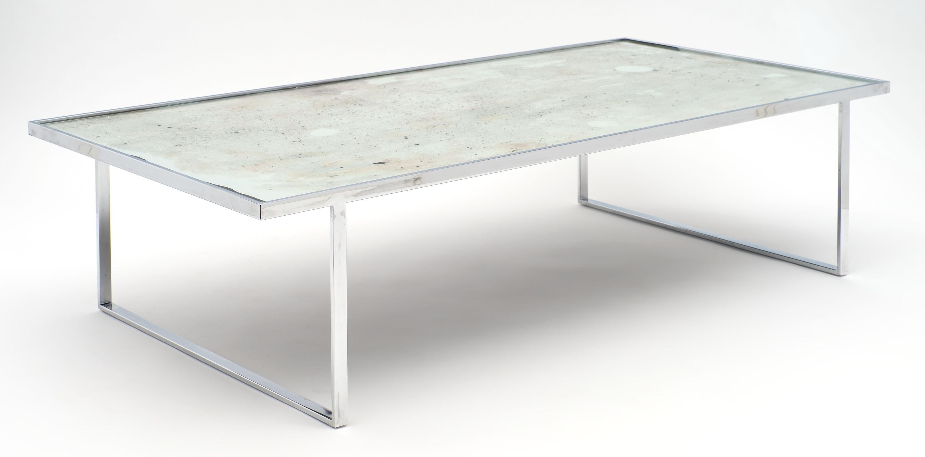 A French vintage chrome and glass coffee table featuring a tight chromed steel base topped with an antiqued mirrored top. This piece is elegant in its simplicity and strong in its construction.