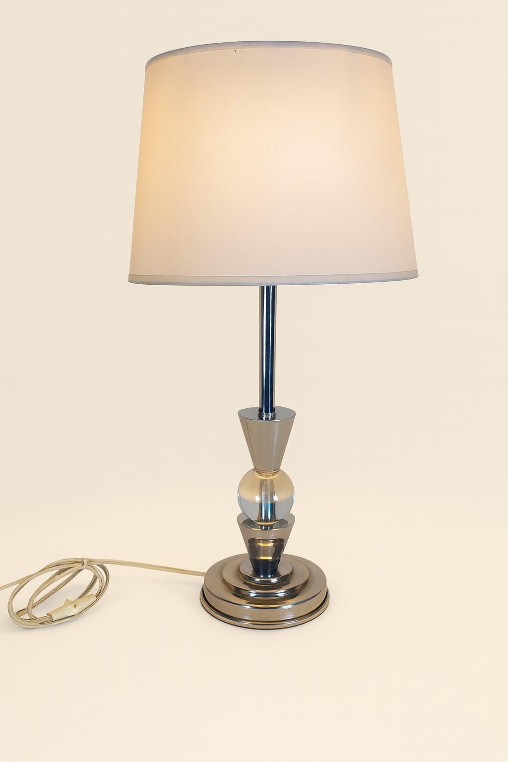 Beautiful table / desk lamp in the style / attributable to Jacques Adnet (1900-1984) in column form with chrome figures and transparent crystal ball.

Very good condition. No marks or shocks.

Electricity checked and original button.

35 cm at the