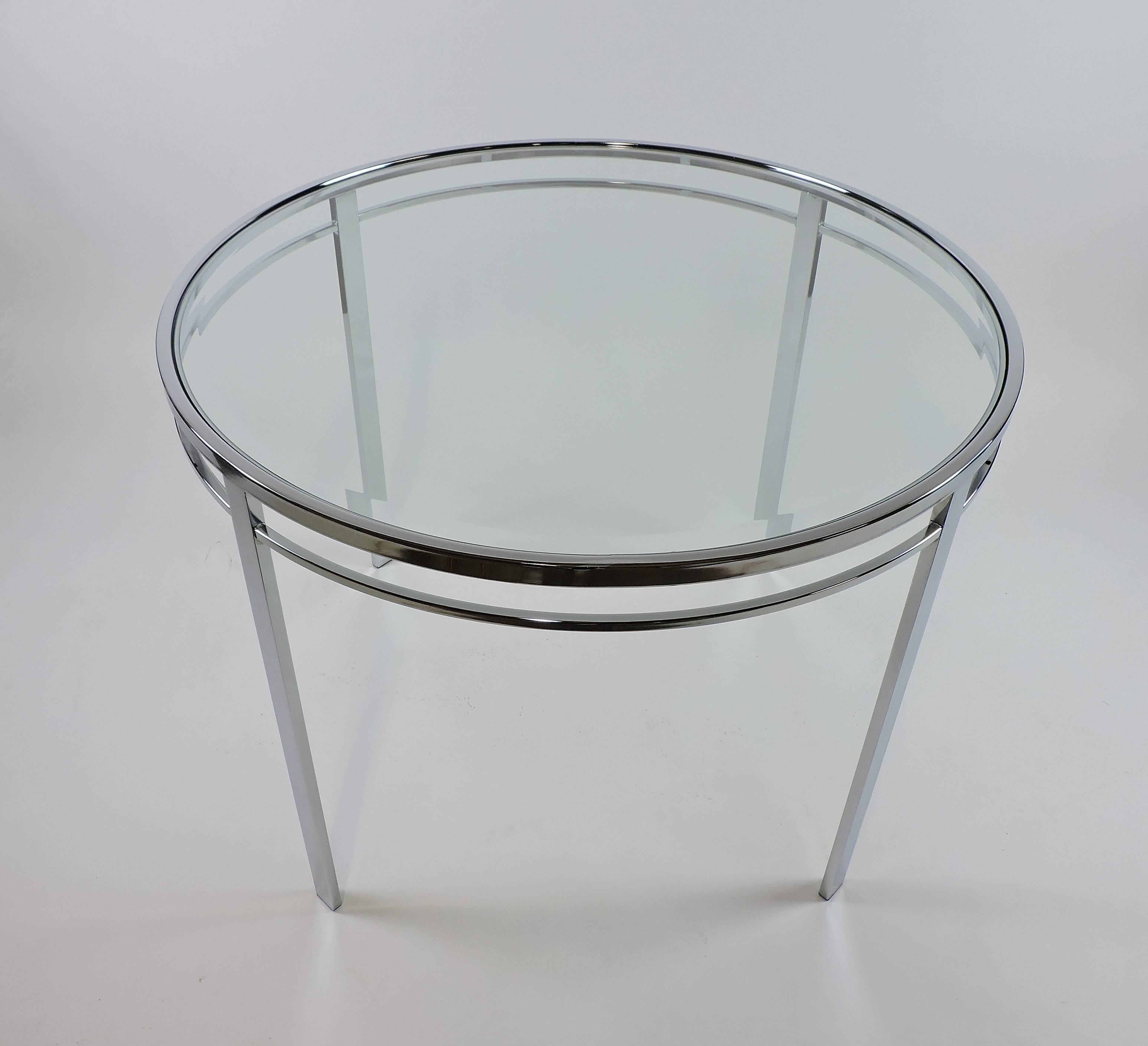 Beautiful round dining or kitchen table made of chrome with a glass top with a beveled edge. It has clean and simple lines and is perfect for small spaces or in a kitchen.
  