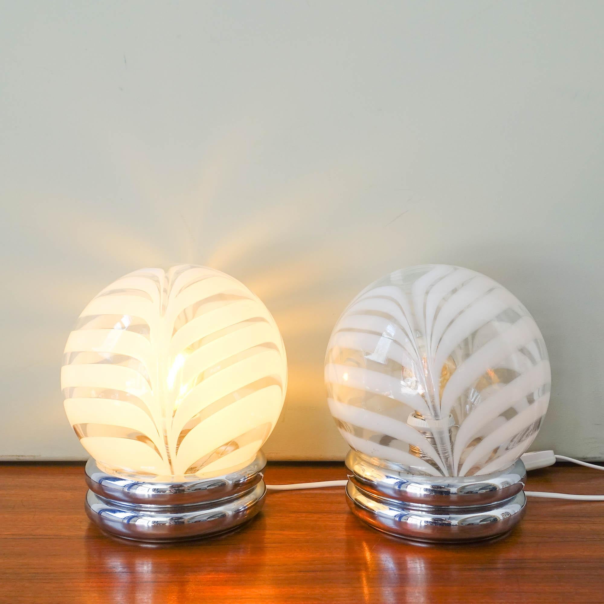 This pair was designed and produced by Marinha Grande Glass Factory, in Portugal during the 1970's. Each lamp features a chrome base where sets a blown clear and white glass globes from Marinha Grande
The glass is transparent with milk color swirl