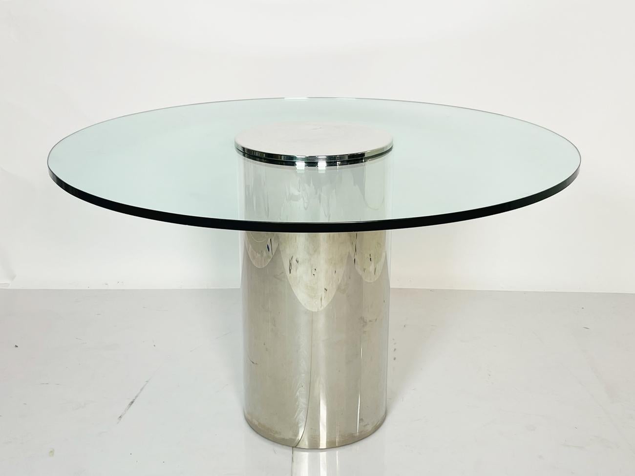 Introducing the stunning Chrome and Glass Pedestal Table by Pace Collection, Circa 1970s, the perfect addition to your home or office space. This beautifully crafted piece features a round glass table top that rests atop a sleek chrome metal base,