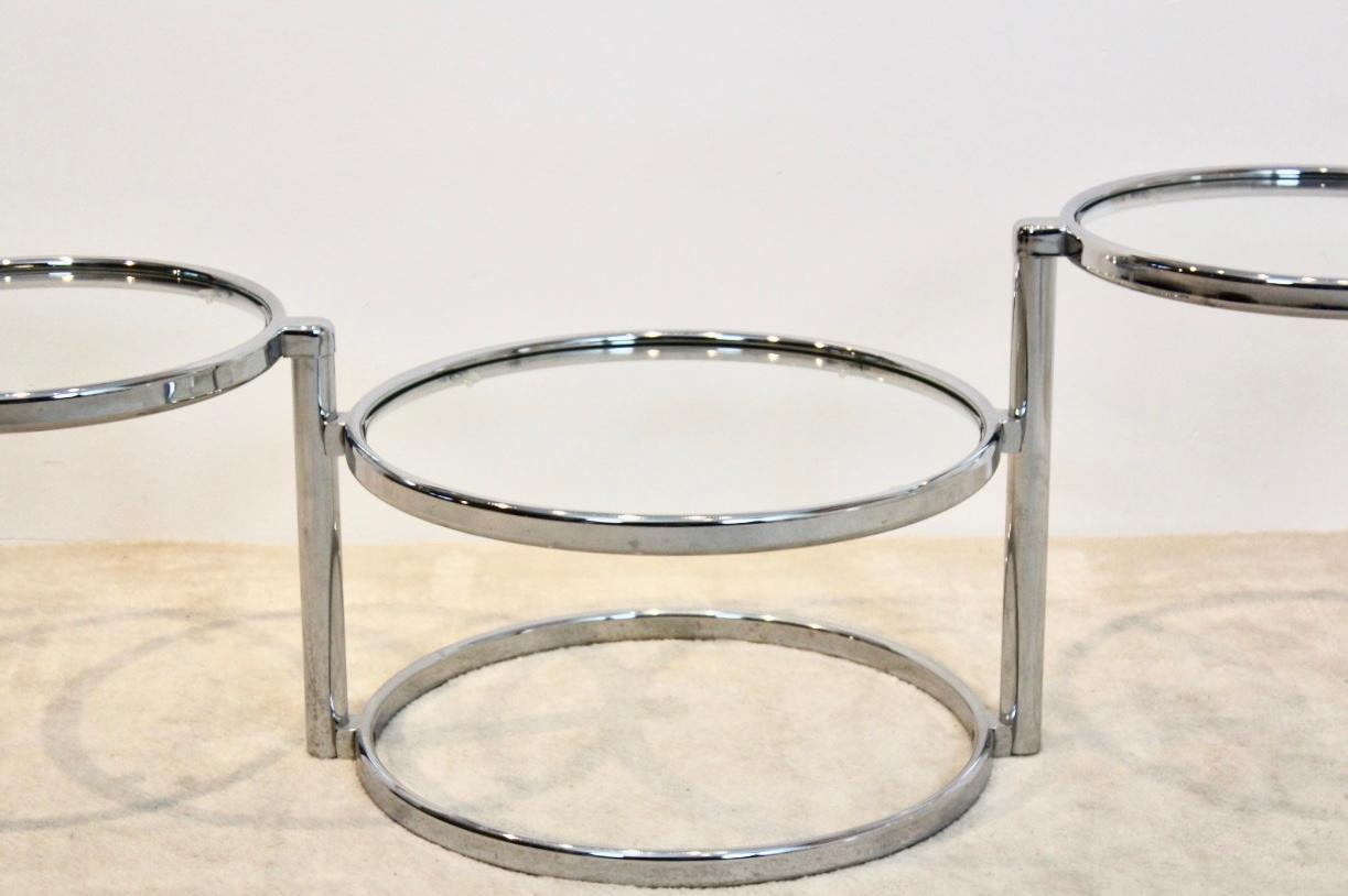 Sophisticated chrome and glass three-tier side table or coffee table. Solid chrome frame with three adjustable round tiers with clear glass. Very nice graphical design with glamorous performance. In excellent condition.