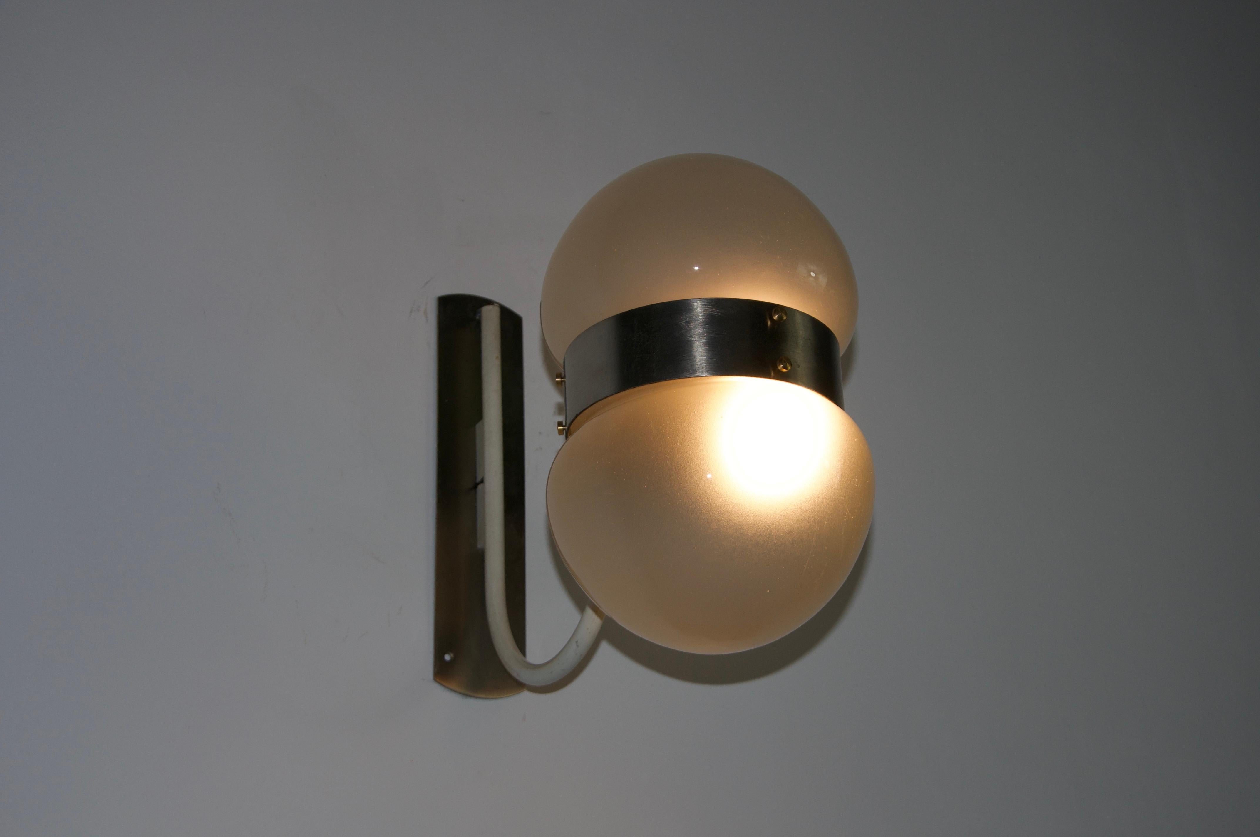Diese elegante Wandleuchte wurde von Sergio Mazza in den 1960er Jahren entworfen und zeigt die für den Designer typische Mischung aus industrieller Präzision und raffiniertem Modernismus.

Die aus verchromtem Metall und mattiertem Glas gefertigte