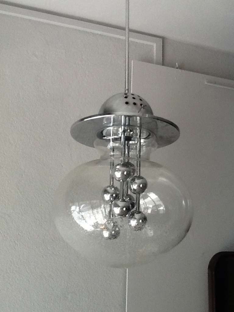 Clear glass globe chandelier appears as if there are water droplets at the bottom of the light fixture. Multi chrome balls are centered within the glass globe.
The chandelier has been recently rewired and can use four light bulbs maximum 40 watts