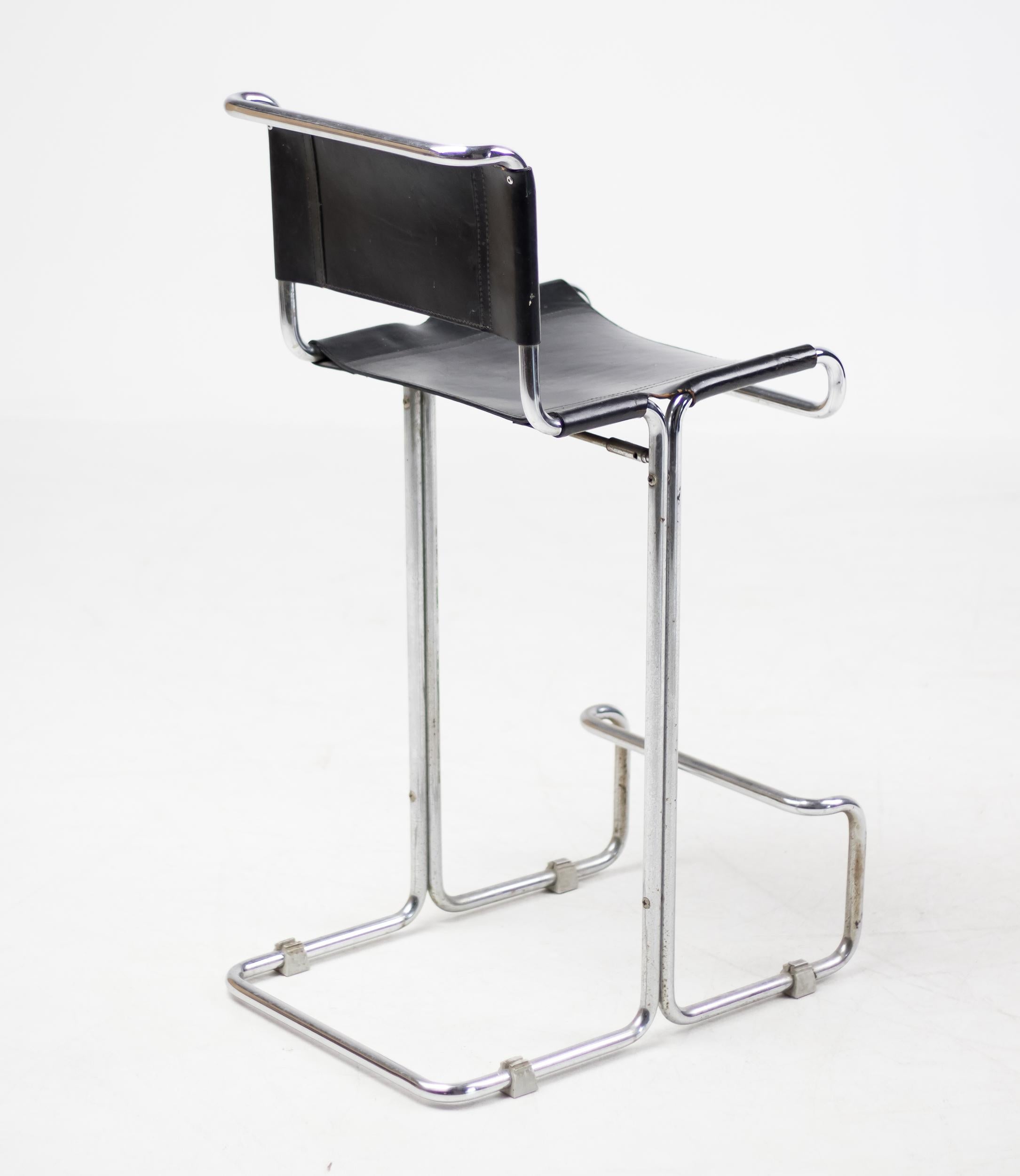 Unique leather and tubular chromed steel bar stool.
All original black saddle leather sling seat and back.
Great patina, very comfortable.