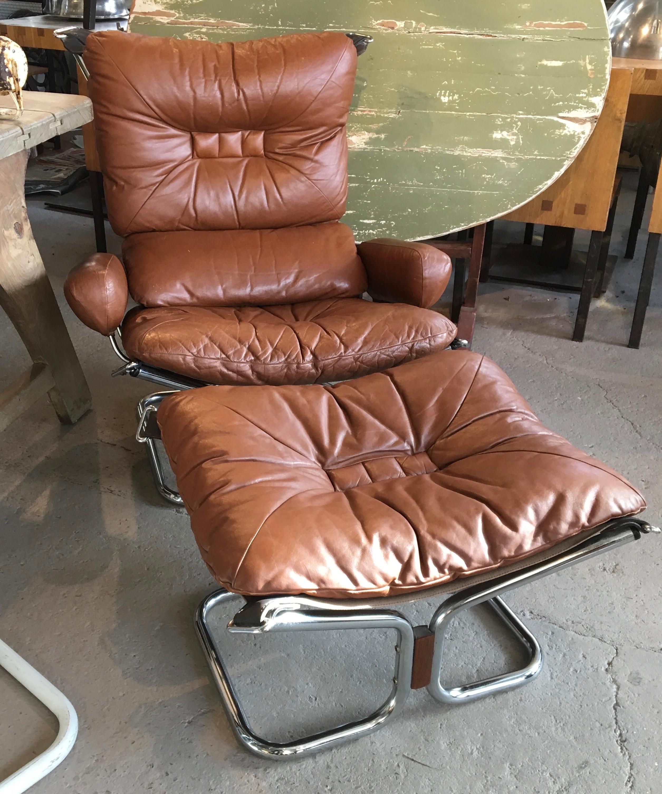 Tubular chrome lounge chair with original leather upholstery and cushions, matching ottoman, and rosewood detail, designed by Ingmar Relling for Westnofa, Norway, 1970s.