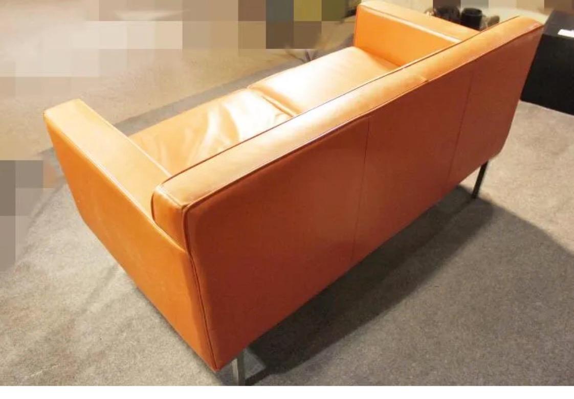 With a combination of vivid orange leather and a chrome frame, this loveseat features a comfortable and minimal design with a pop of color. Please confirm item location with seller (NY/NJ).