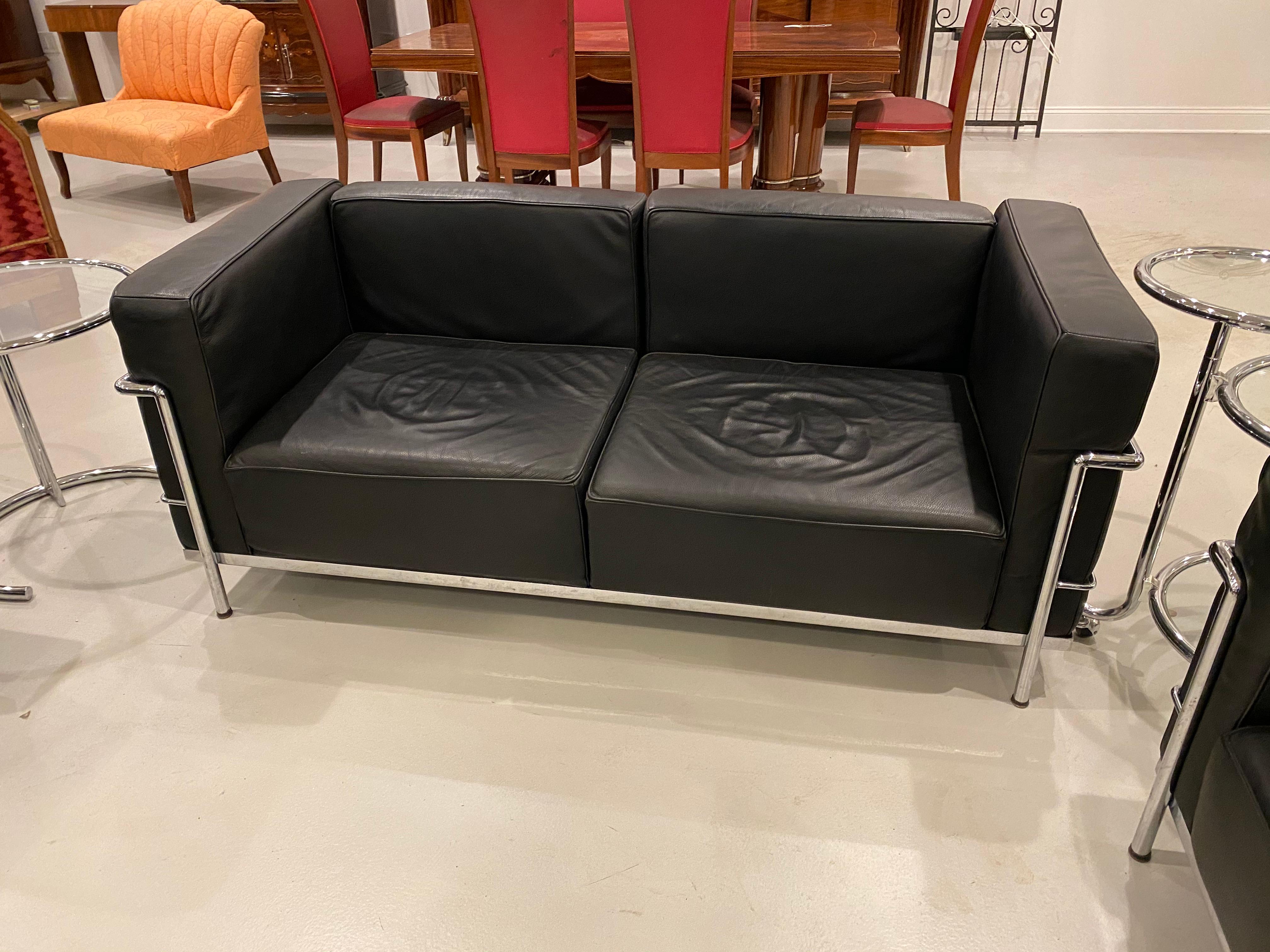 Magnifique et élégant canapé en chrome et cuir noir dans le style de Le Corbusier.