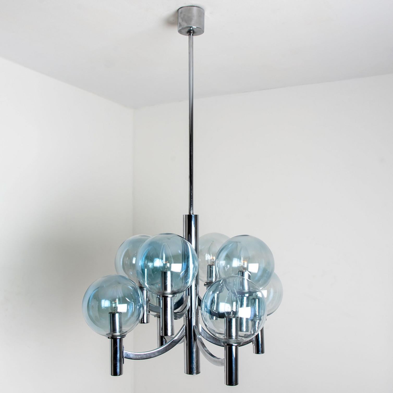Wonderful chandelier with light blue glass bowls and a chrome base and fittings. Produced in the 1970s in the style Hans-Agne Jakobsson. Illuminates beautifully.
The chandelier has 8 blue toned glass bulbs fixed on a chrome frame.

Size of the