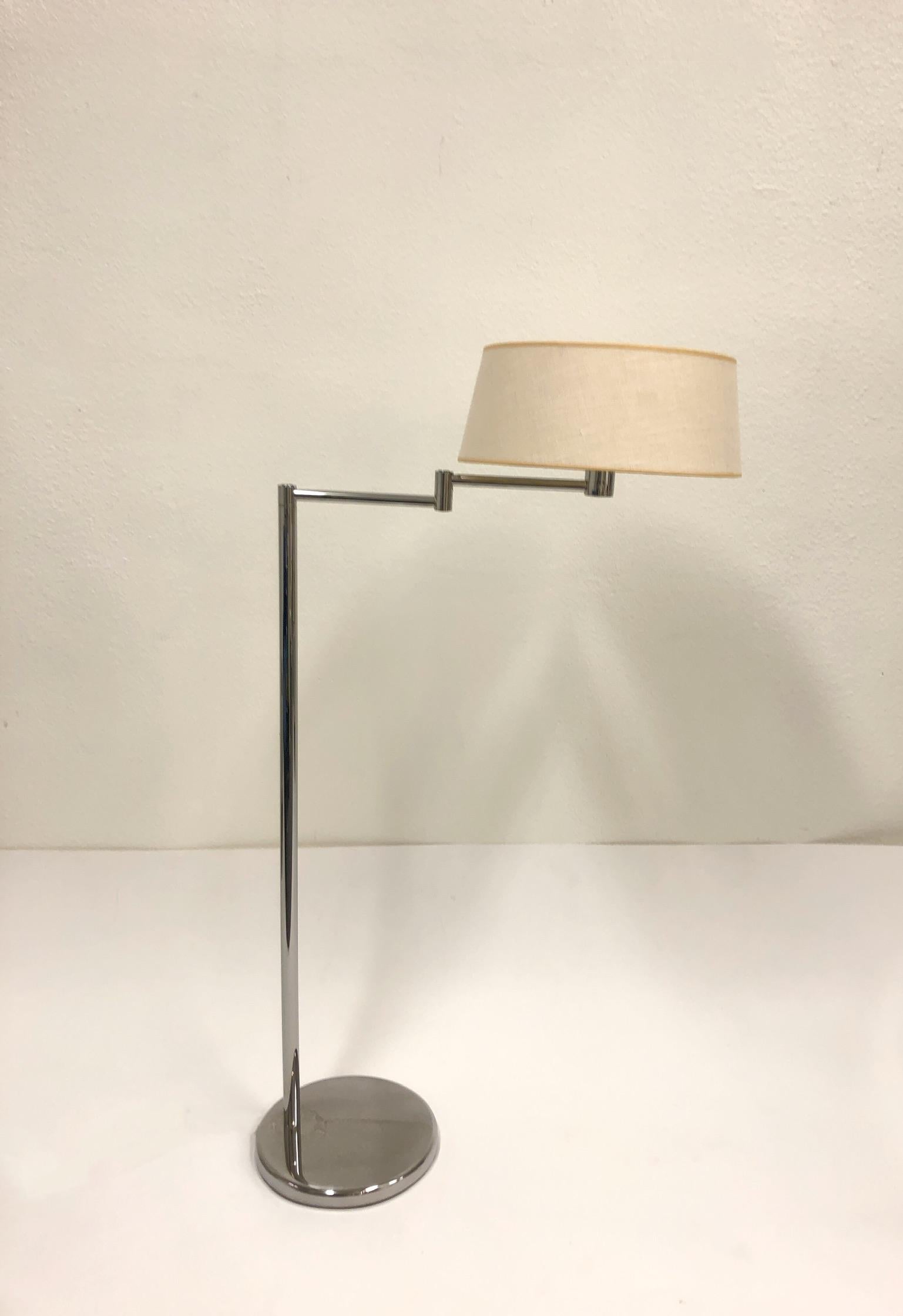 A 1970s polish chrome with a vanilla linen shade adjustable floor lamp by Walter Von Nessen for Nessen Studios. The lamp has a swing arm and it raises up and down. Newly rewired. 
Dimensions: 47.25” high, 26.5” wide (when arm is extended) 15” deep.