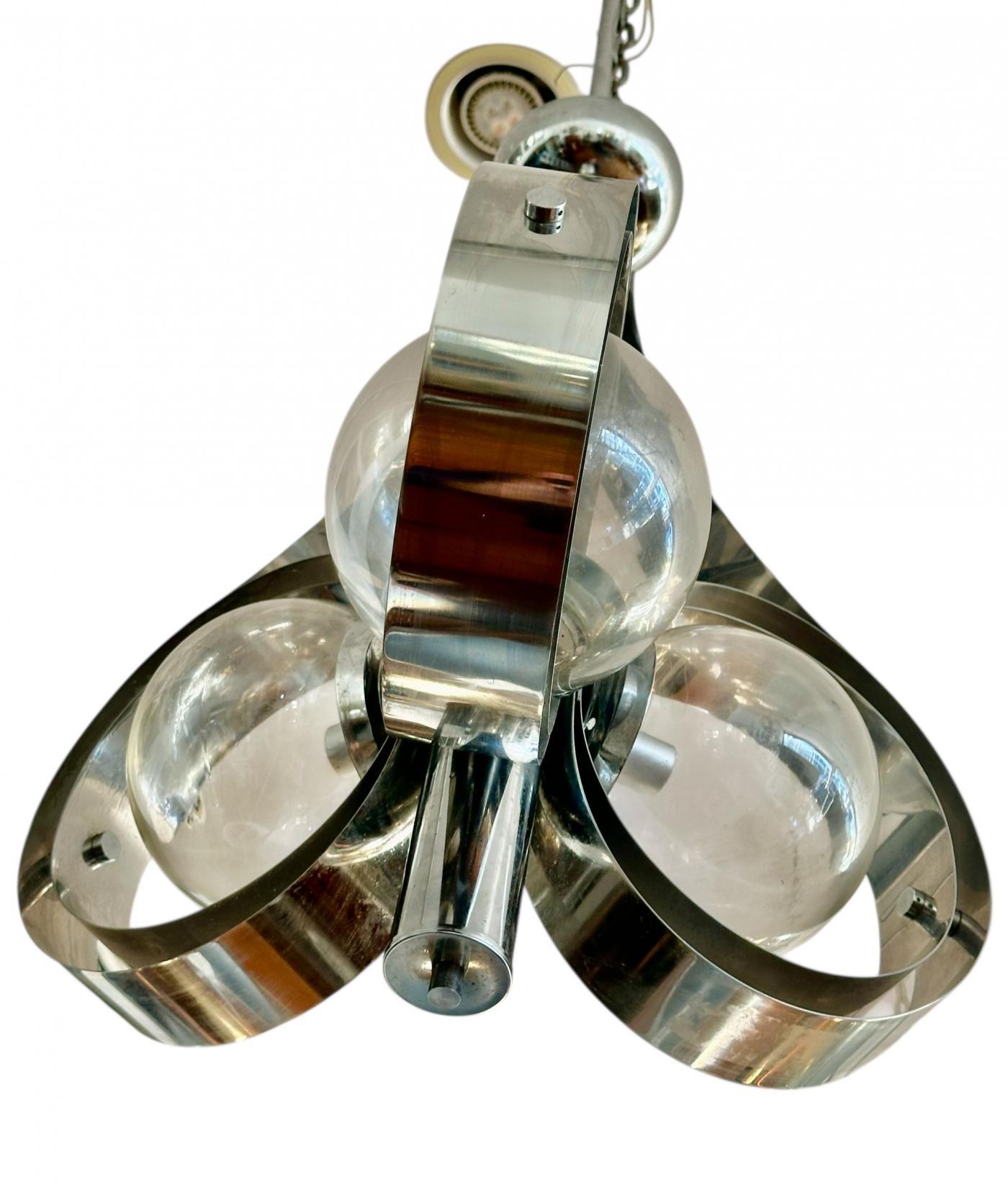 Designed by Mazzega , exemplifies the Space Age and modernist design aesthetic popular during this period , featuring chrome metal frames and three Murano glass globes . 