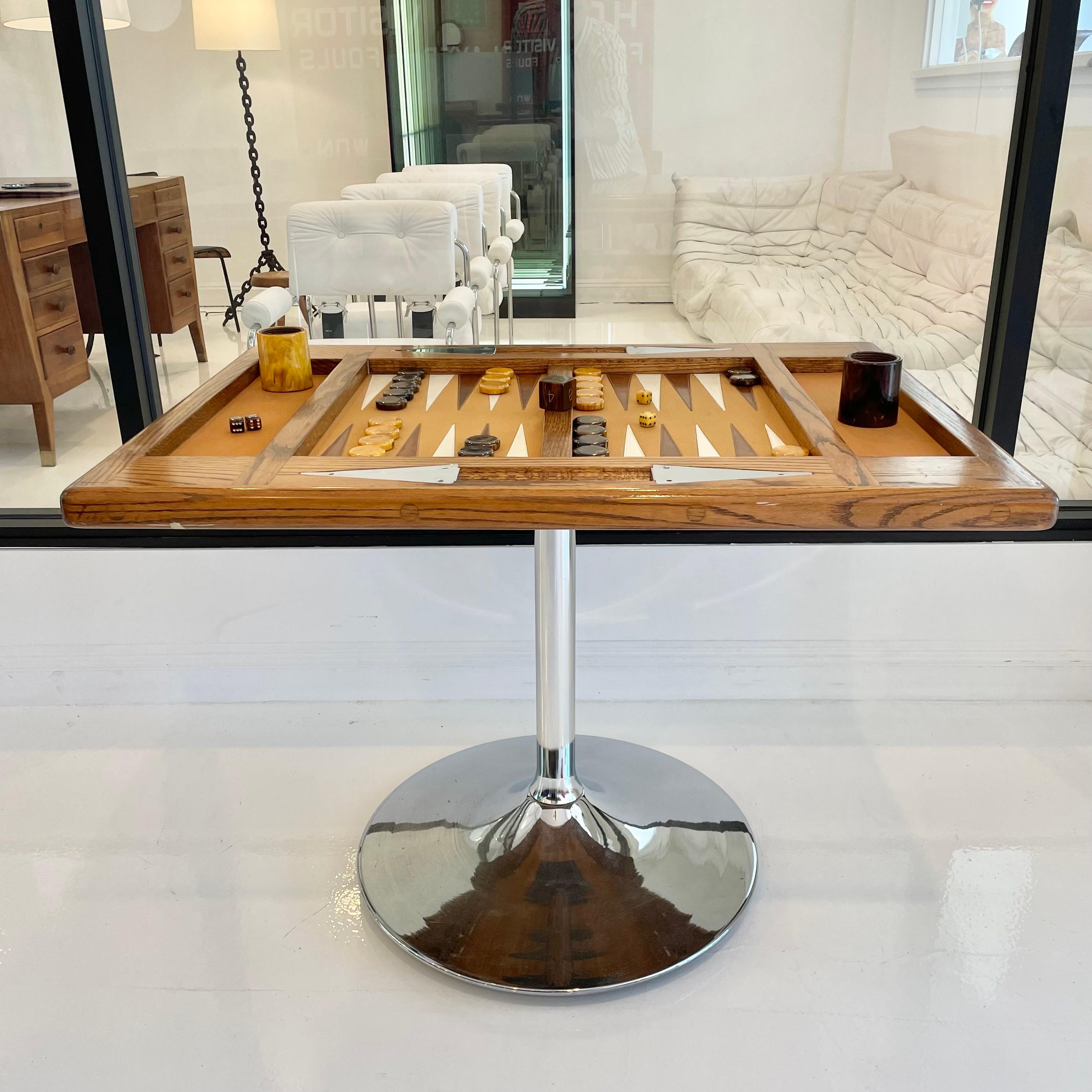 Beautiful oak and chrome backgammon table with a tulip base. Large Bakelite game pieces with perfect coloring and matching dice cups. Massive doubling cube. Carmel felt top with alternating tan and cream leather triangles. Tulip base gives you